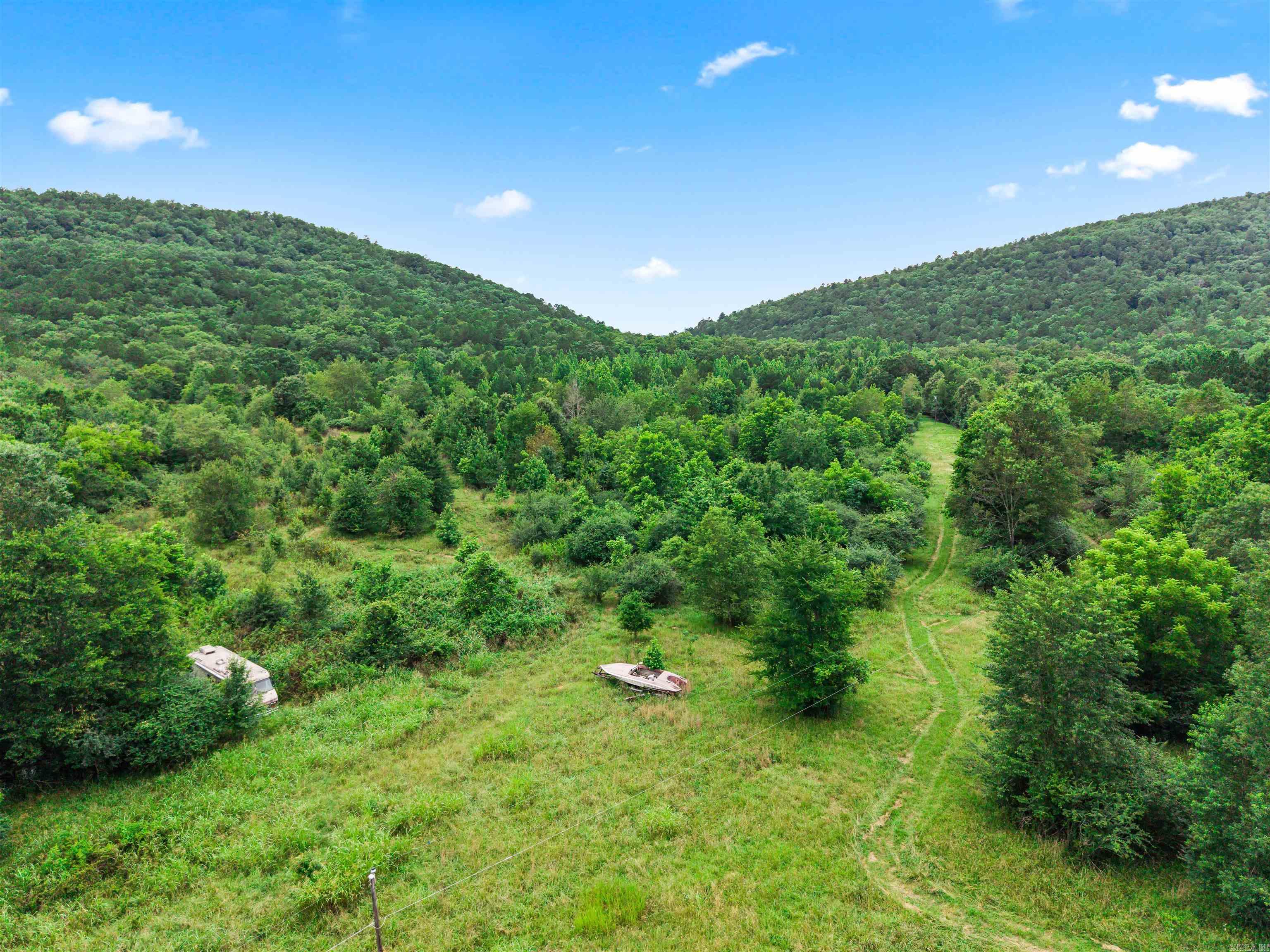 This rare 39 +/- acre tract offers the perfect blend of rugged natural beauty, ultimate privacy, and an unmatched location. The dynamic landscape features rolling hills that give way to a dramatic mountain slope, offering sweeping mountain views, two rain-filled ponds that attract local wildlife, and multiple potential building sites. Whether you want to build a premier family estate, create a private off-grid retreat, or develop near the city's heartbeat, this acreage is a blank canvas waiting for your vision. Value is entirely in the land. While the property currently features a home, a 2-car garage, and a horse barn, all structures are in poor condition, hold no financial value, and are sold strictly as-is. However, a savvy buyer can take advantage of the existing footprint and established utility access points to clear the way for a custom dream home or cabin. Don't miss this rare opportunity to own a massive footprint of land in one of the area's most desirable pockets. Bring your builder, your horses, or your mountain bikes, and claim your piece of paradise today.