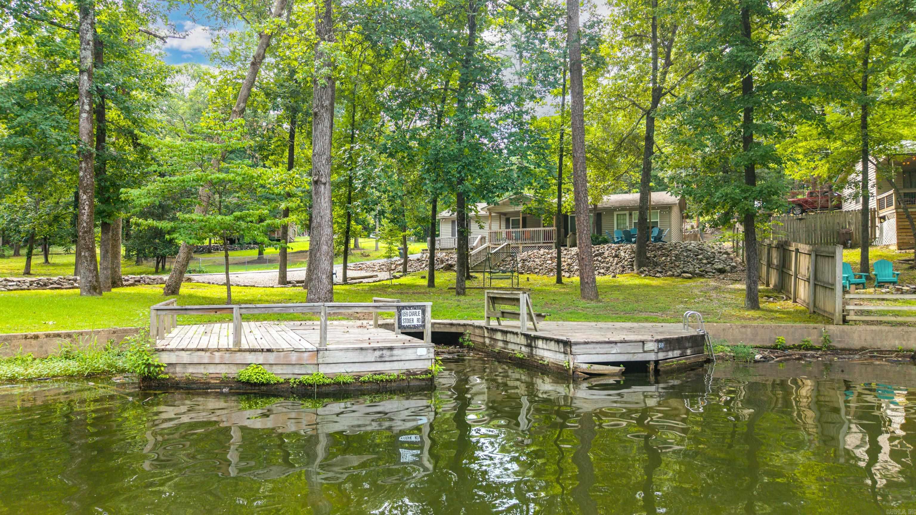 Discover your dream waterfront retreat on Lake Hamilton! This remodeled 4 bedroom/2 bathroom home combines modern luxury with peaceful, rural serenity. The interior features a thoughtful layout, offering three spacious bedrooms on one side of the home and a large, versatile bunk room on the other--perfect for large families or hosting guests. The home showcases premium finished throughout, including stunning quartz countertops and brand new stainless steel appliances. Designed for outdoor enthusiasts, the property features 102 feet of lake frontage and a swim dock with boat slip. Relax on the expansive covered deck, gather around the fire pit, or unwind on the swing while taking in peaceful lake views. The property also includes two outdoor storage buildings for all your lake gear. Seller will sell furnished with an acceptable offer. Perfectly turnkey and ready for lakefront living!