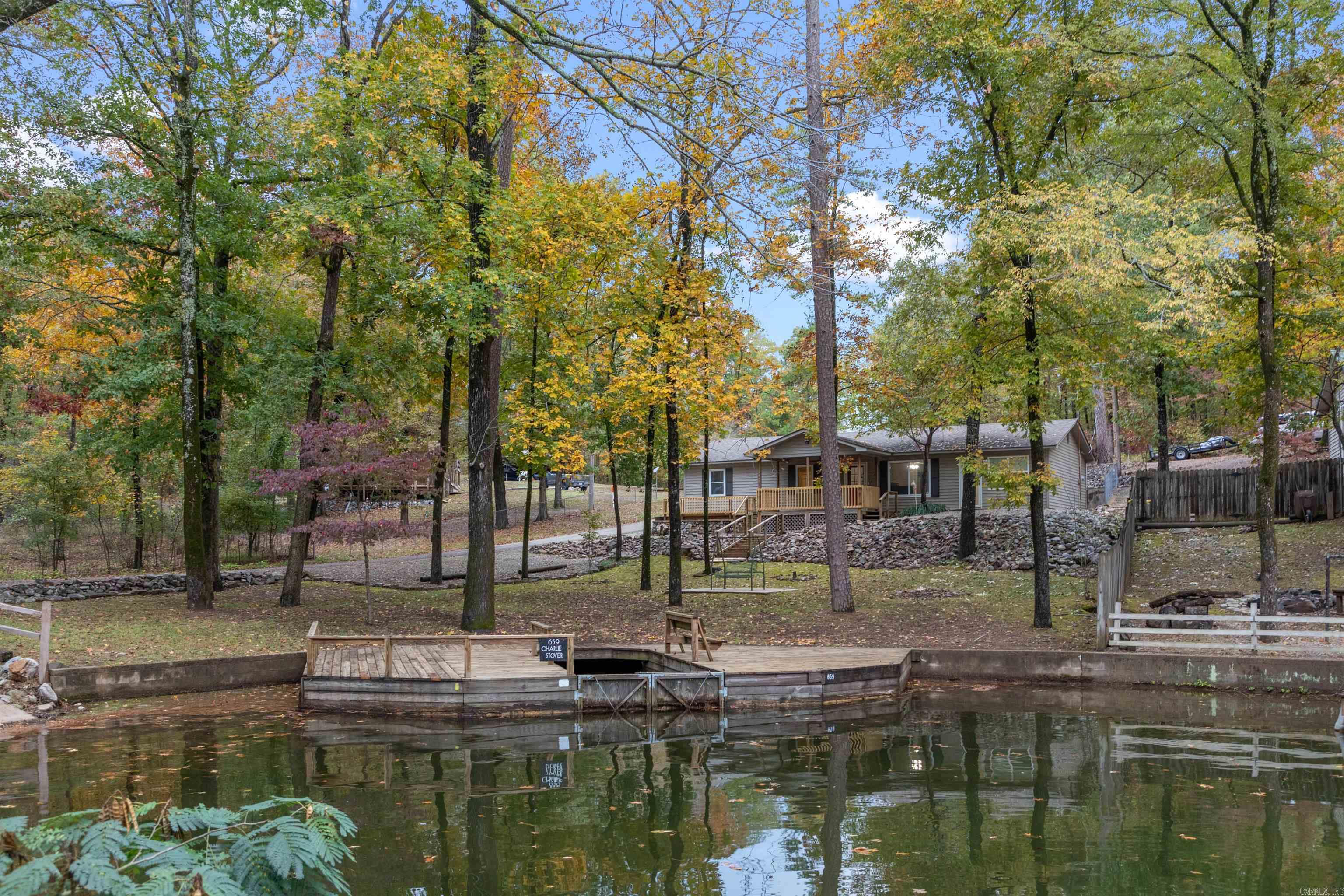 Discover your dream waterfront retreat on Lake Hamilton! This remodeled 4 bedroom/2 bathroom home combines modern luxury with peaceful, rural serenity. The interior features a thoughtful layout, offering three spacious bedrooms on one side of the home and a large, versatile bunk room on the other--perfect for large families or hosting guests. The home showcases premium finished throughout, including stunning quartz countertops and brand new stainless steel appliances. Designed for outdoor enthusiasts, the property features 102 feet of lake frontage and a swim dock with boat slip. Relax on the expansive covered deck, gather around the fire pit, or unwind on the swing while taking in peaceful lake views. The property also includes two outdoor storage buildings for all your lake gear. Seller will sell furnished with an acceptable offer. Perfectly turnkey and ready for lakefront living!