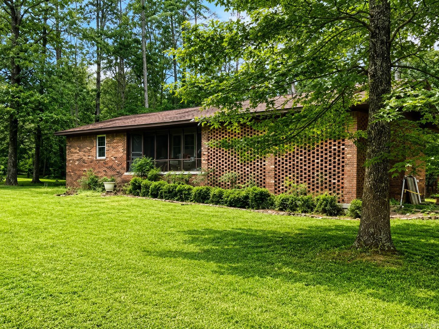 Nestled on approximately 1.27 wooded acres just minutes from Clinton and only a short drive to Greers Ferry Lake, this brick home offers privacy, mature shade trees, and a peaceful country setting. The property features a spacious yard, screened front porch, and plenty of room to enjoy outdoor living. Whether you're looking for a primary residence, weekend retreat, or investment opportunity, this property offers excellent potential in a desirable location. Convenient to shopping, schools, and recreational opportunities while still enjoying the quiet of country living. Additional photos will be added as estate preparations are completed.