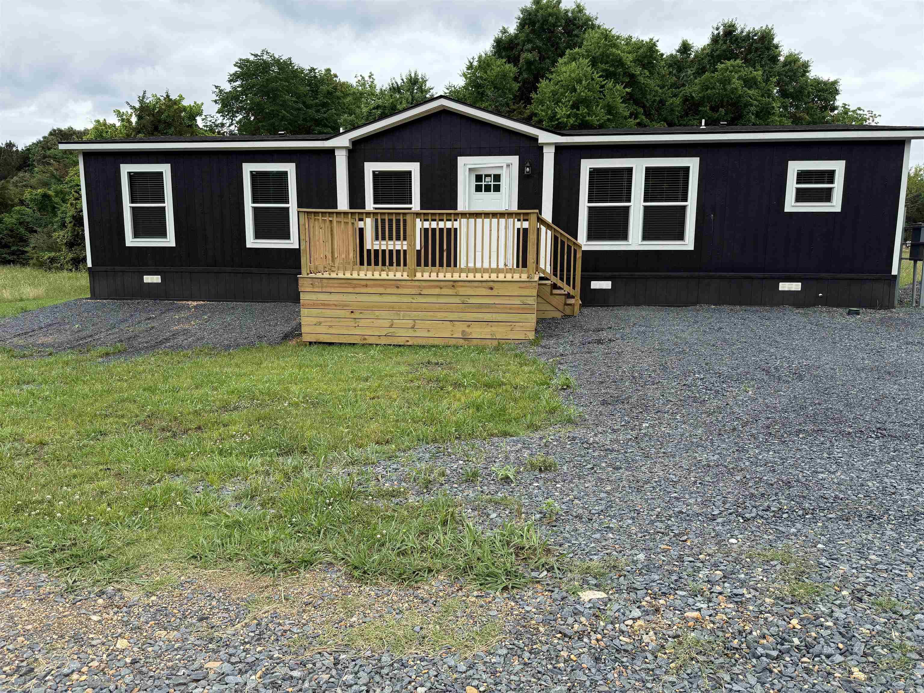 2025 model 3-bedroom, 2 bathroom manufactured home offering approximately 1,568 sq ft with bold modern farmhouse styling throughout. This beautifully finished home features black accent trim, custom feature wall, sliding barn door, recessed lighting, and an open concept floor plan designed for both comfort and entertaining. The spacious kitchen includes stainless steel appliances, oversized island seating, abundant cabinetry, and striking black-and-white finishes. Split bedroom layout provides privacy, while the primary suite offers a walk-in closet and private bath. Permanently affixed to the ground on a concrete slab, making it eligible for government financing per engineering certification requirements. Move-in ready with modern style and functionality throughout. See documents on file for a copy of the Energy Star Certification