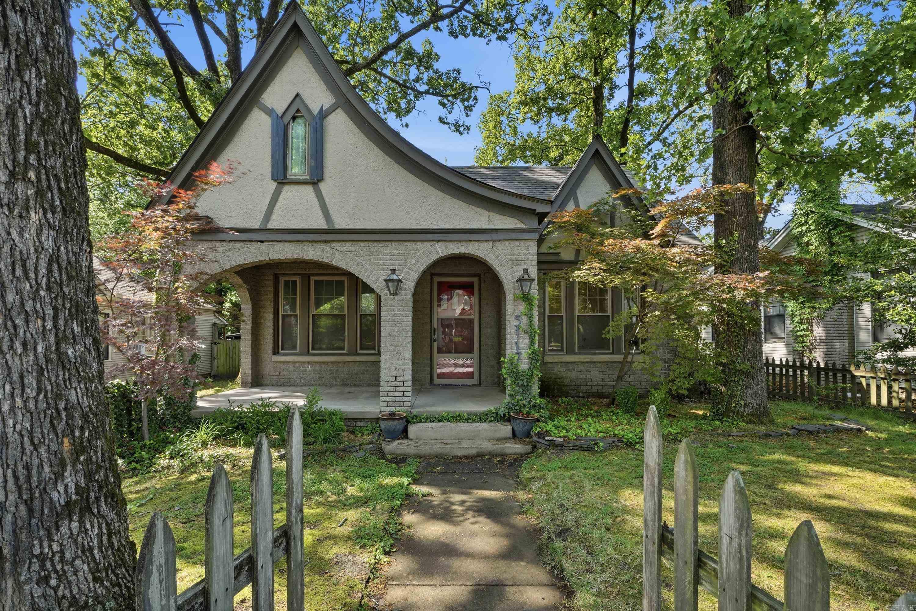 Some mornings, you just know you're exactly where you're supposed to be. That's the feeling 5117 Cantrell Road delivers — a 1930 Tudor-inspired craftsman bungalow sitting quietly in one of Little Rock's most irreplaceable neighborhoods. The lower level welcomes you with real hardwoods and the kind of character that took a century to earn. The back of the home opens into a flexible living space that flows naturally onto a large deck and patio — the conversation lingers and Tuesday evenings feel like weekends. Upstairs, the fully remodeled second level functions as a suite, where updated comfort meets original soul. New roof in 2026. Forest Park Elementary is a walk away. You’re just a short walk from both Hillcrest and The Heights—where local restaurants, charming shops, cozy coffee spots, and neighbors who quickly become friends all come together. This is the rare home where historic charm isn't a selling point — it's a lived experience. The hardwoods, the architecture, the century of story embedded in every room — it's all still here, waiting for whoever comes next.
