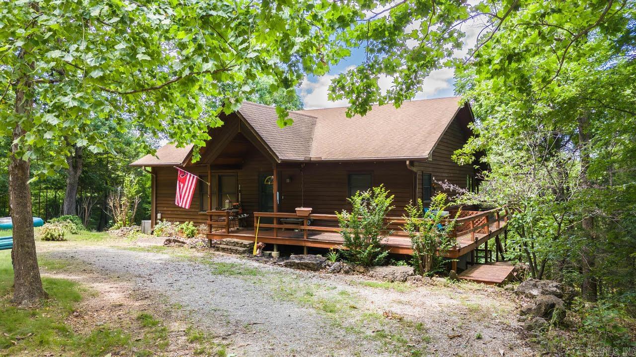 Experience direct Spring River frontage on 3.05 acres located on a private drive in Riverside Resort, where elevated positioning ensures no flooding in recent years. This 2,560 sq ft home offers a rare dual-living layout with 1,280 sq ft on each level, each featuring its own kitchen, living space, bedroom(s), and full bath. The main level includes two bedrooms, a full bath with shower, a gas fireplace, and access to an upper deck overlooking the property. The lower level provides a second kitchen area, bedroom, full bath with tub and separate shower, room for another bed, and walk-out access to the lower deck. Steps lead directly from the home to the Spring River bank, placing you on a premier stretch known for exceptional trout fishing near the falls. Ideal for multi-generational living, private retreat use, or flexible guest, this riverfront property combines privacy, accessibility, and long-term peace of mind in a truly unique setting.
