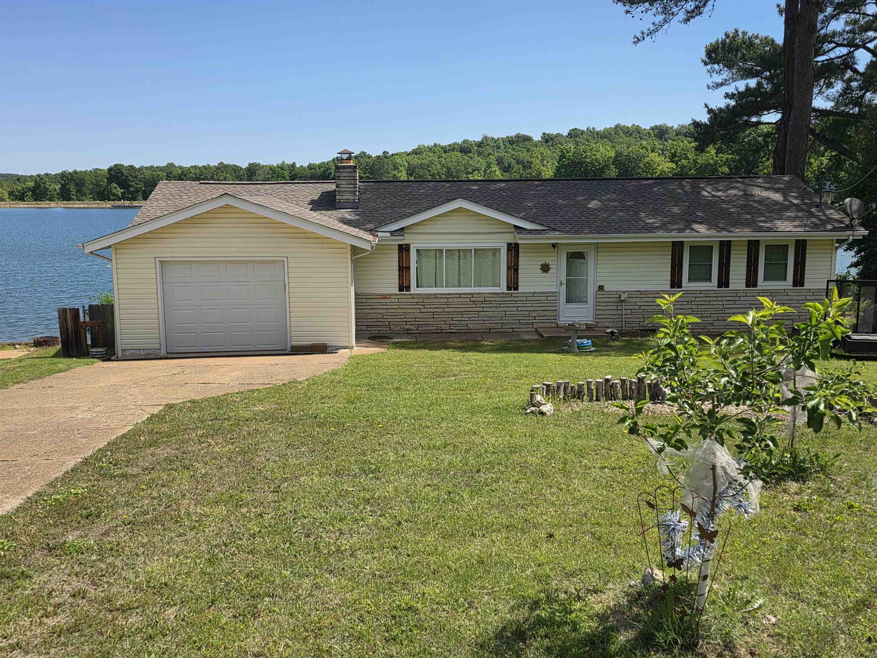 Lakefront home with outstanding views. This 3-bed, 2-bath home on Lake Sequoyah comes with a partially covered back deck that overlooks Lake Sequoyah. 2 beds and 1 bath are on one end of the house, and 1 bed and bath are at the other end of the home. This home is located near the dam so deep-water access is right out your back door. It has nearly a full-length sunroom with its own ductless HVAC system. It has a boat dock along with over 125' of lakefront shoreline. Prime location for fishing and swimming. There is a shop/ basement/ storage area. New Architectural Shingle roof in 2022. New septic system in 2023.   Nice sized one-car garage with remote door opener. All electric aside from the beautiful gas-log fireplace and an on-demand water heater. Located in a cul-de-sac so there is minimal road noise or traffic. Brand new hardwood floors just installed. Most furniture and appliances stay making this a truly move in ready home. Make an appointment to come see this beauty and start planning your afternoons on the lake and evenings on the back deck.