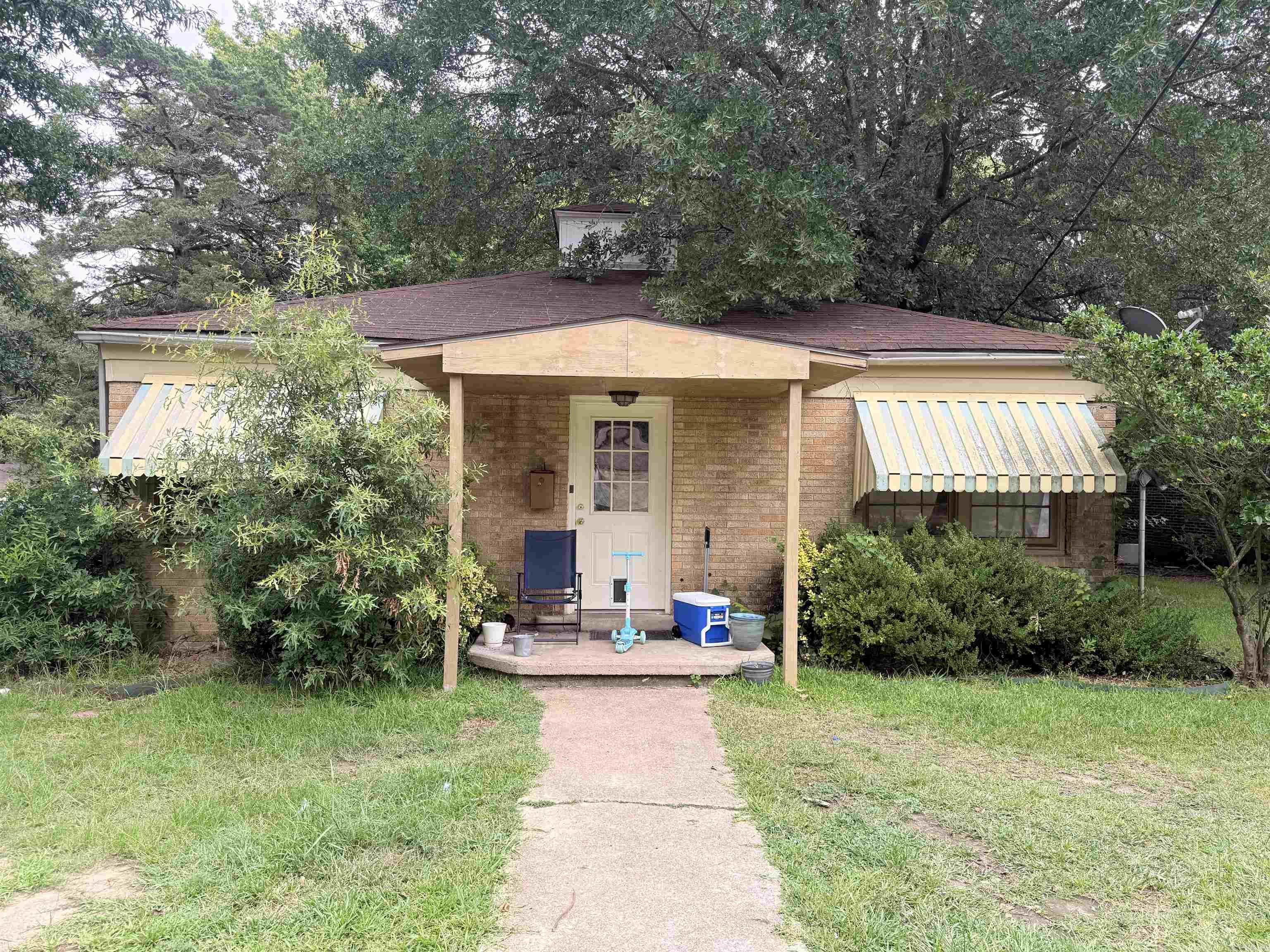 This inviting single-story brick ranch offers a covered front porch with classic striped awnings, perfect for relaxing under the shade of mature trees. Featuring three bedrooms, one bathroom, and a functional layout, the home sits on a generous lot with a detached carport for covered parking and extra storage. Currently tenant-occupied for $800/month, making this an excellent turnkey income-producing property. Conveniently located just off Main Street, it’s ideal for investors or buyers seeking immediate cash flow along with solid, character-filled bones and room to grow. Great curb appeal and endless potential!