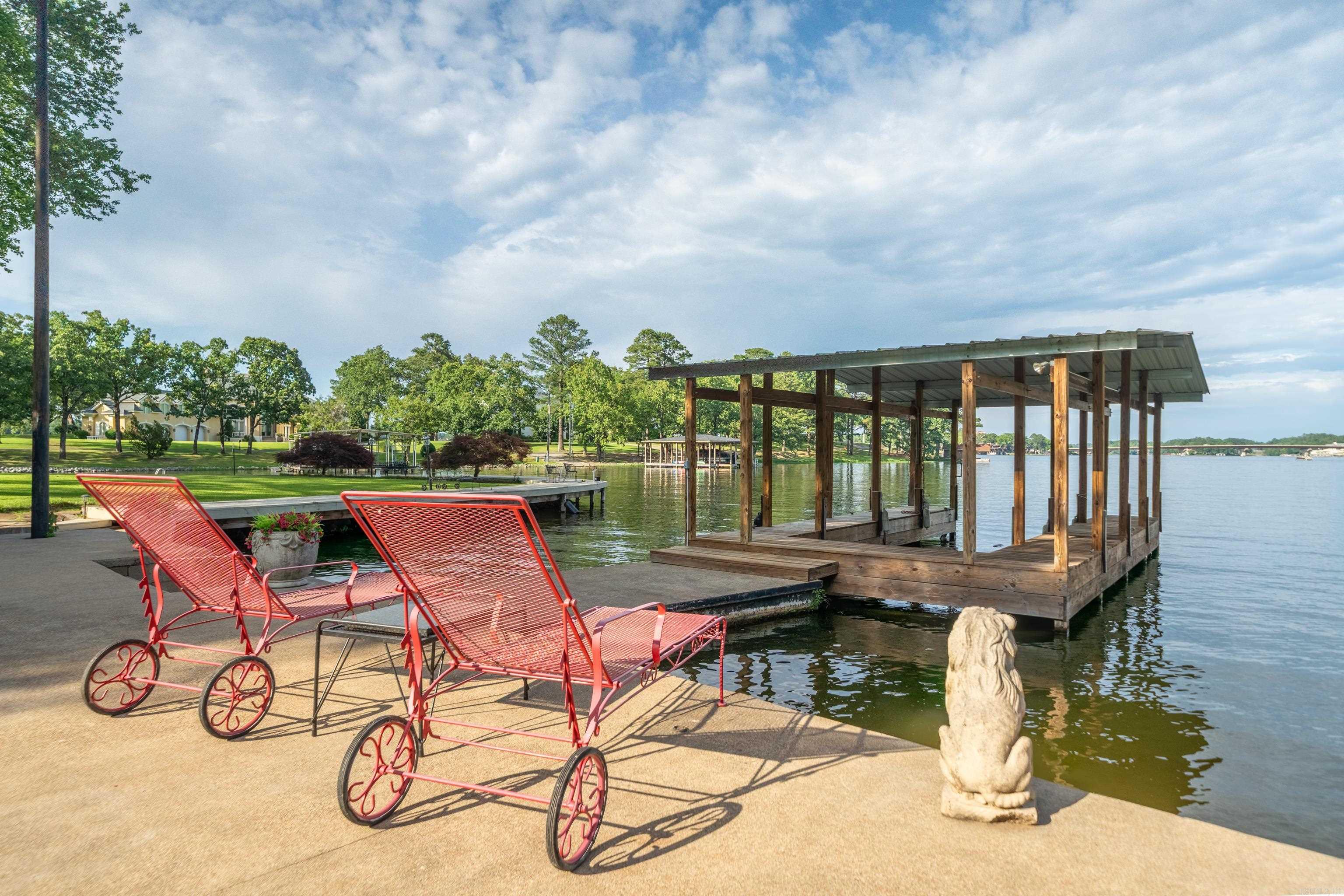 Check out this unique opportunity to own a lake house with acreage on Lake Hamilton. A beautiful covered boat dock has additional concrete boardwalks and walkways to maximize your lake fun. The large yard leading to the lake has a gentle slope allowing for yard games or the addition of a stunning pool.  112 Spurwink is a 4 bed/ 2 bath fixer upper with 2 kitchens a 2 entertaing spaces that has been partially demoed to see its potential.  Both living areas are full of windows to bring the picturesque lake views front and center. There is a 2 car garage attached -- plus, an oversized, extra tall 3-vehicle carport for parking RVs, boats, etc.  The expansive 1.12 acres allows for additional building site(s) or room for a garden. Make your appointment for a private tour today!