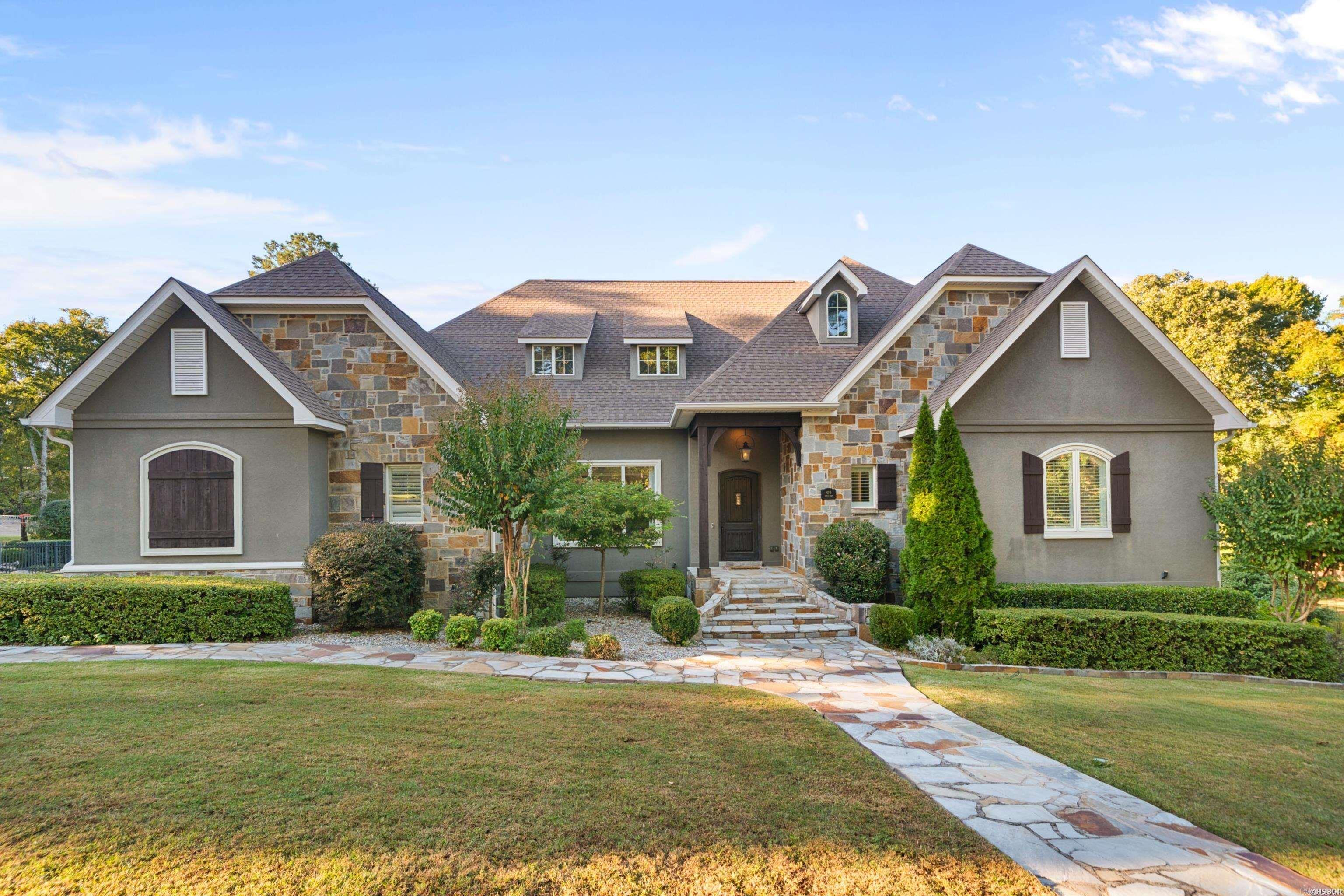 Welcome to this exceptional custom-built home located in the highly coveted Lotus Valley subdivision. This stunning residence offers the perfect blend of elegance, comfort, and craftsmanship, with thoughtful details and luxurious finishes throughout. Boasting over 5,600square feet of living space, this home features five spacious bedrooms, four full baths, and two half baths, providing ample room for family and guests. Situated on two beautifully landscaped lots, the property offers a sense of privacy and tranquility rarely found. Multiple covered patios create ideal spaces for outdoor living and entertaining, while the expansive green space surrounding the home provides plenty of room for recreation, gardening, or simply enjoying the natural setting. Whether hosting large gatherings or quiet evening outdoors, this property is designed for every occasion. Step inside to an inviting open-concept floor plan highlighted by soaring vaulted ceilings, abundant natural light, and rich hardwood floors that flow throughout the main living areas.
