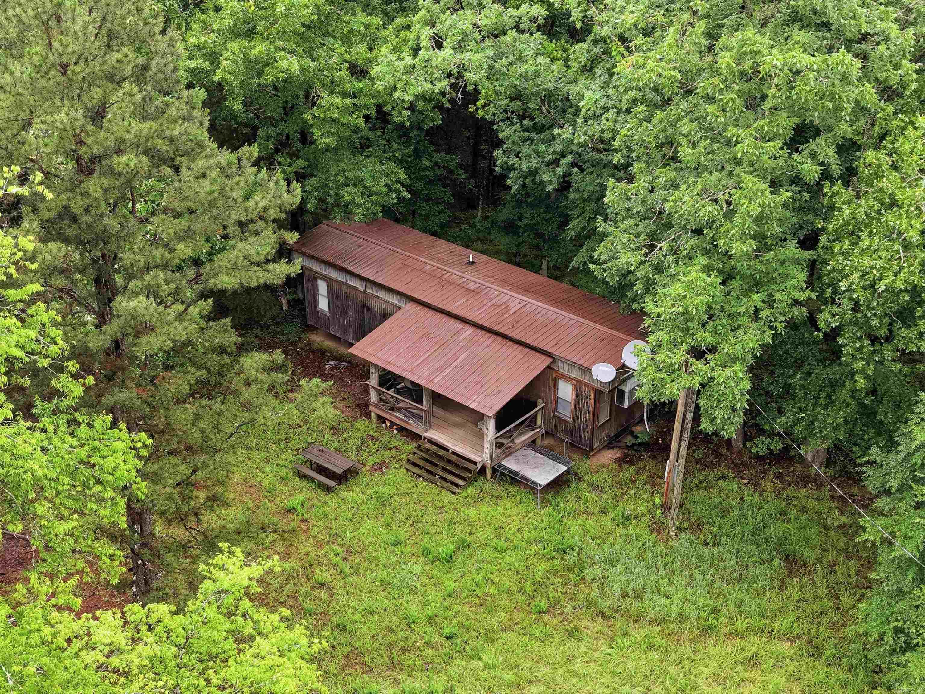 OUTDOOR ENTHUSIASTS - Discover the perfect recreational getaway or investment opportunity with this beautiful 20-ACRE property located near LAKE Nimrod that borders the Ouachita NATIONAL FOREST. Minutes from Lake Nimrod you are able to Enjoy Prime fishing, boating, hiking and ATV trails. Small Cabin is 1 Bedroom 1 Bath and has power and well water on site. Ideal for a weekend getaway, hunting retreat, ATV fun, future homesite, or investment opportunity.  EXCELLENT hunting opportunities both on the property and throughout the surrounding national forest that this property borders on 2 sides: Front & Back. A mobile home/cabin is situated on a non-permanent foundation here and with some modifications this home could be a 2 bedroom, with full kitchen and full bath. Making this an even more comfortable tiny home or base camp for weekend adventures, hunting trips, or future improvements. Whether you’re looking for a private retreat, hunting property, investment opportunity, or a place to enjoy the outdoors, this property offers endless potential and is UNIQUE with it's BORDERS of NATIONAL FOREST.  Land has a good solid road entry off Brush Creek Rd, a Seasonal Creek and Pond built.