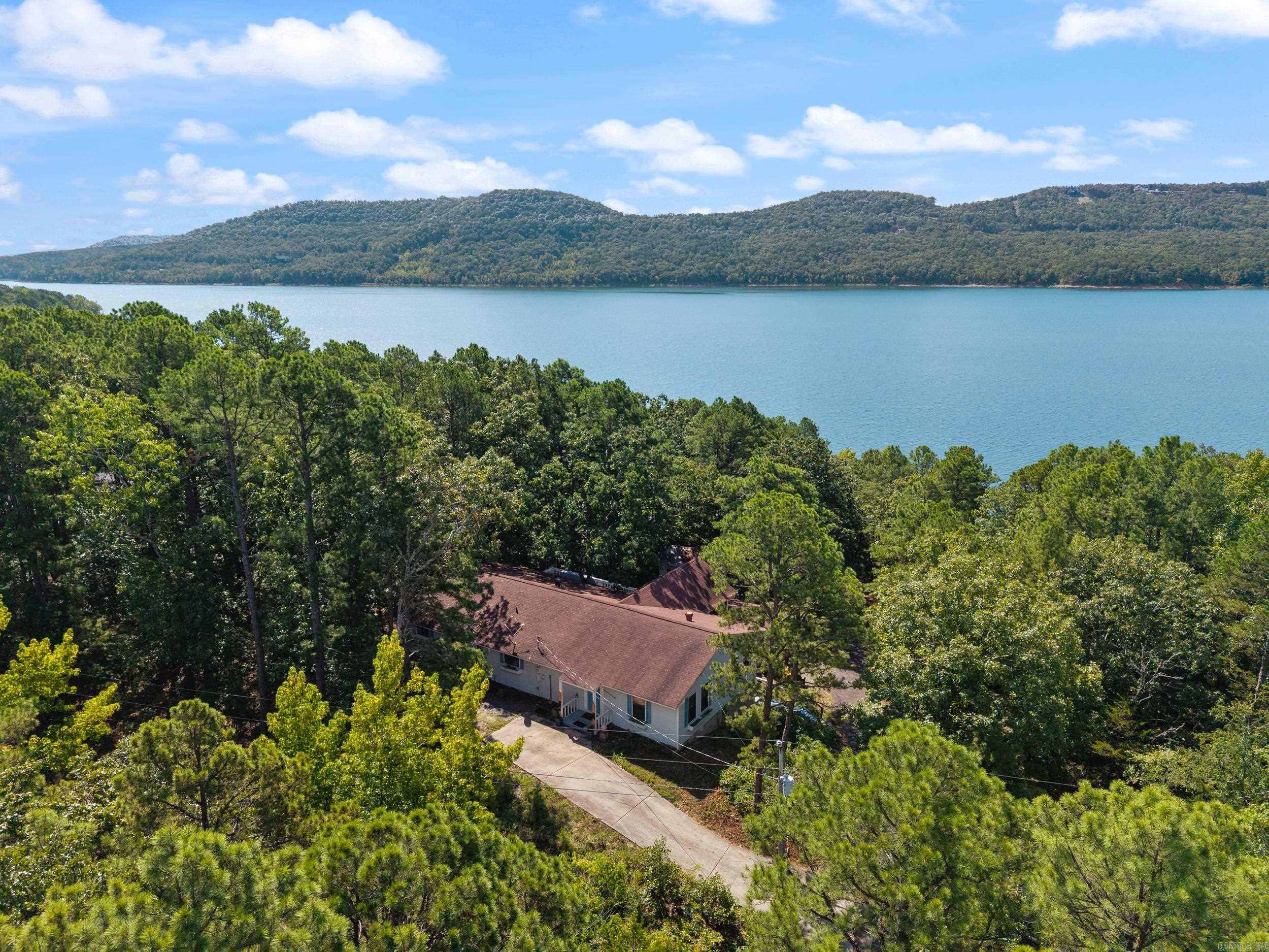 Welcome to your perfect lakefront retreat where comfort, space, and scenic beauty come together. This stunning home offers 4 bedrooms and 3 full baths, thoughtfully designed for both relaxation and entertaining. Step inside to discover a beautiful, oversized kitchen that truly serves as the heart of the home, featuring a massive stainless-steel island, ample counter space, and room to gather with family and friends. Just beyond, a bright and inviting sunroom provides the perfect spot to enjoy your morning coffee while taking in serene lake views. The property is made for fun and flexibility, boasting a dedicated game room complete with its own hot tub, shower, and restroom—ideal for hosting guests or unwinding after a day on the water. An additional bunkhouse that comfortably sleeps 6 offers even more space for visitors, making this home perfect for weekend getaways or extended stays. Outside, enjoy direct lakefront access with an easy walking path leading you right to the water’s edge. Whether you’re fishing, kayaking, or simply soaking in the view, this property delivers the ultimate lakeside lifestyle. Make this beautiful home and the unbeatable location yours today!