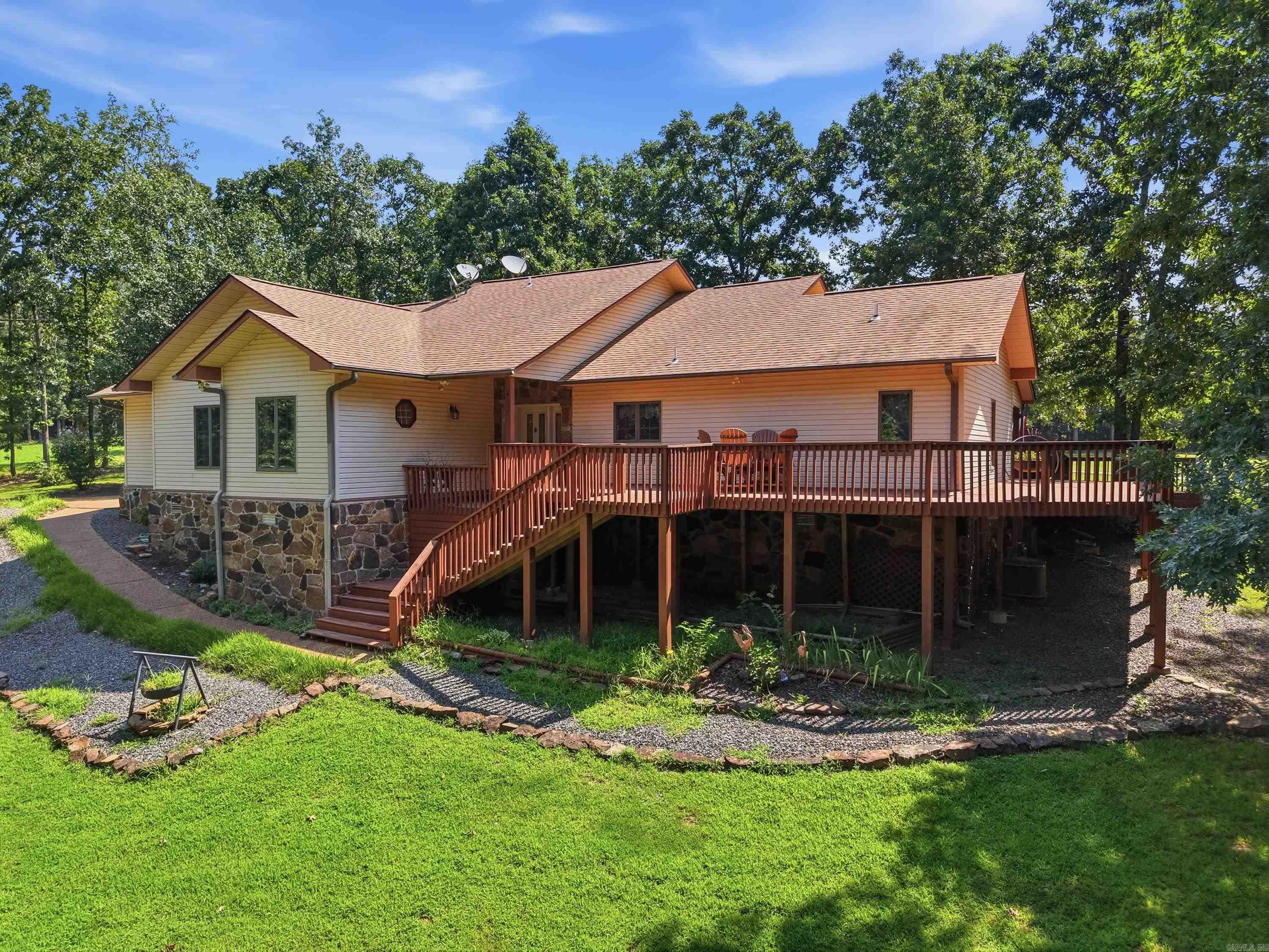 Enjoy the perfect blend of golf, lake and resort-style living in this fully furnished home situated on Indian Hills Golf Course in beautiful Fairfield Bay! Set on a spacious double replatted lot, this inviting, move-in-ready retreat offers updated luxury vinyl flooring, newer heating and air, a newer water heater, plus a new refrigerator, washer and dryer. Gather with family and friends in the comfortable living area featuring a beautiful stone fireplace with gas logs, perfect for cozy evenings after a day on the course or lake. The new beds also convey, including a Sleep Number California king adjustable bed for added comfort. Step outside onto the expansive wraparound deck, where you can relax, entertain or simply enjoy the peaceful wooded and golf course surroundings. The large garage provides plenty of room for vehicles, storage and hobbies, along with a separate golf cart garage for easy access to the course. Greers Ferry Lake and a convenient boat launch are only about seven minutes away. Located close to Fairfield Bay’s pools, pickleball, tennis, ATV/UTV trails, marina and other popular amenities. Pack your bags and start enjoying golf, lake days and the relaxed lifestyle.