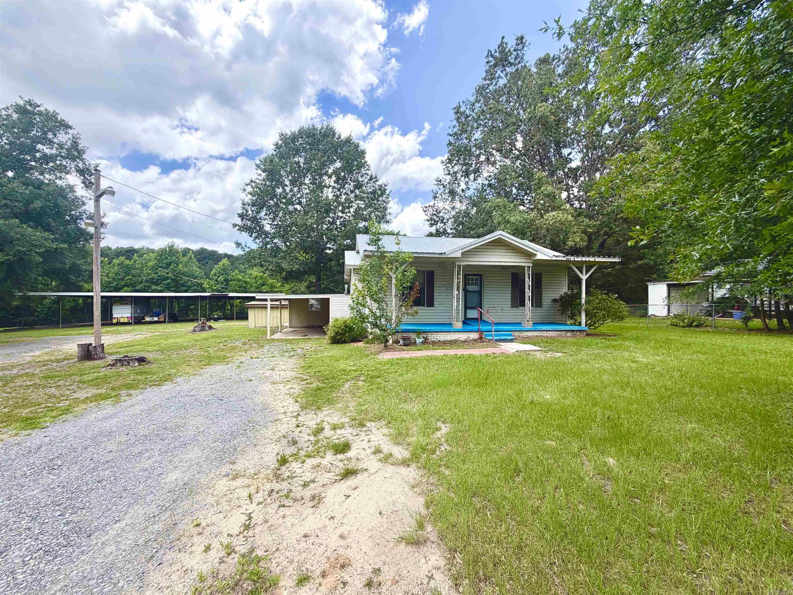 Discover the potential of this 3-bedroom, 2-bath home situated on 2.58 acres of land. This versatile property offers an additional utility hookup for two mobile homes, creating excellent opportunities for extended family, rental income, or future development.  A standout feature is the impressive 7-bay covered shed, ideal for storing equipment, RVs, boats, vehicles, or operating a small business. The shed is equipped with 200-amp electrical service and security lighting for added convenience and functionality.  Additional improvements include multiple storage buildings, providing ample space for tools, hobbies, and outdoor equipment. With plenty of room to grow and customize, this property is ready for its next owner to make it their own.  Property is being sold "AS IS"