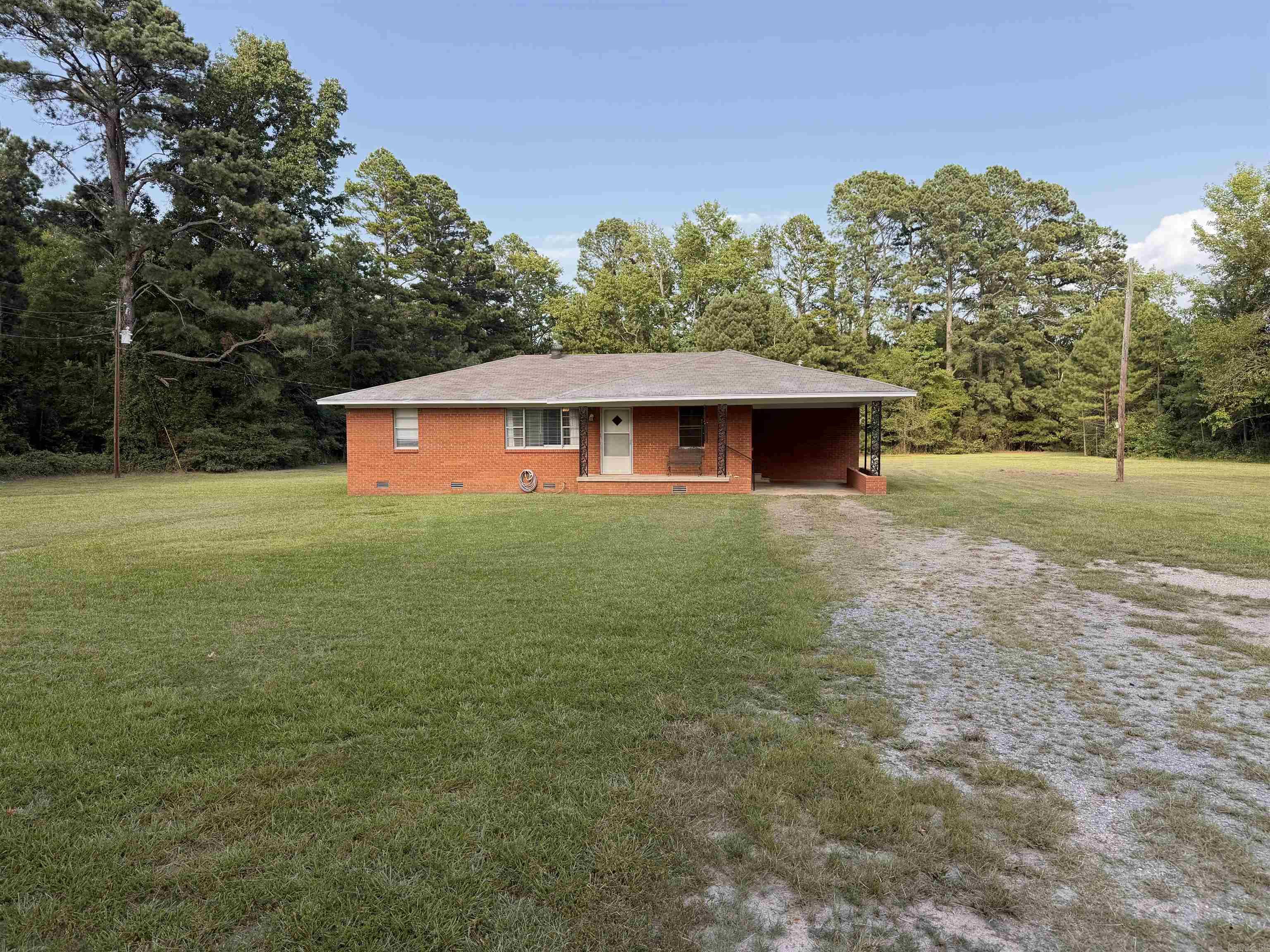 Welcome home to peaceful country living! Nestled on 2 beautiful acres, this charming 3-bedroom, 1-bath brick home offers the perfect blend of comfort, space, and affordability. With 1,362 square feet of well-designed living space, this home is an excellent opportunity for first-time homebuyers, downsizers, or anyone looking to enjoy a quieter lifestyle.  Step inside to find a spacious kitchen with plenty of room for meal preparation, dining, and gathering with family and friends. The home also features a dedicated laundry area for added convenience and comfortable living spaces filled with natural light.  Outside, you'll appreciate the covered carport, expansive yard, and endless possibilities the 2-acre lot provides—whether you dream of gardening, entertaining, adding a workshop, or simply enjoying the outdoors. USDA loan eligible