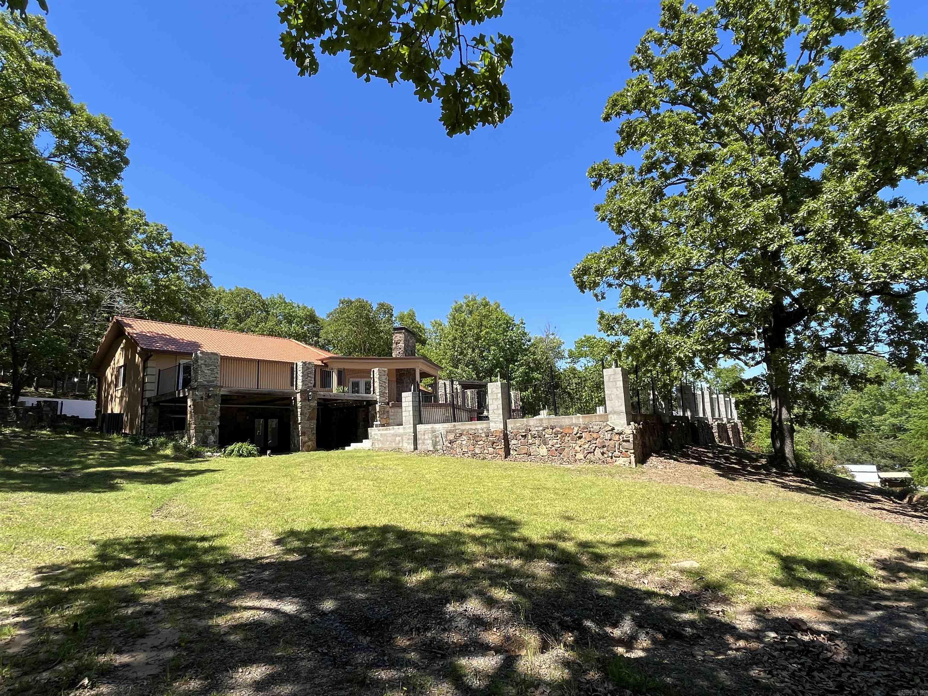 LOCATION! If being in the right spot is what you're after, don't miss out on this beautiful home. It sits about 10 minutes from downtown Russellville, about 2.5 miles away from Interstate 40 access, and less than a mile away from Arkansas Nuclear One! This home is also extremely close to beautiful Lake Dardanelle. You can catch glimpses of it through the leaves. Plenty of space for entertaining with a 1,300+ square foot attached garage, and a giant back deck / patio. The large in ground pool over looking the front yard is the perfect spot to hang out and beat the heat. With a few finishing touches, you could make this house your forever home!