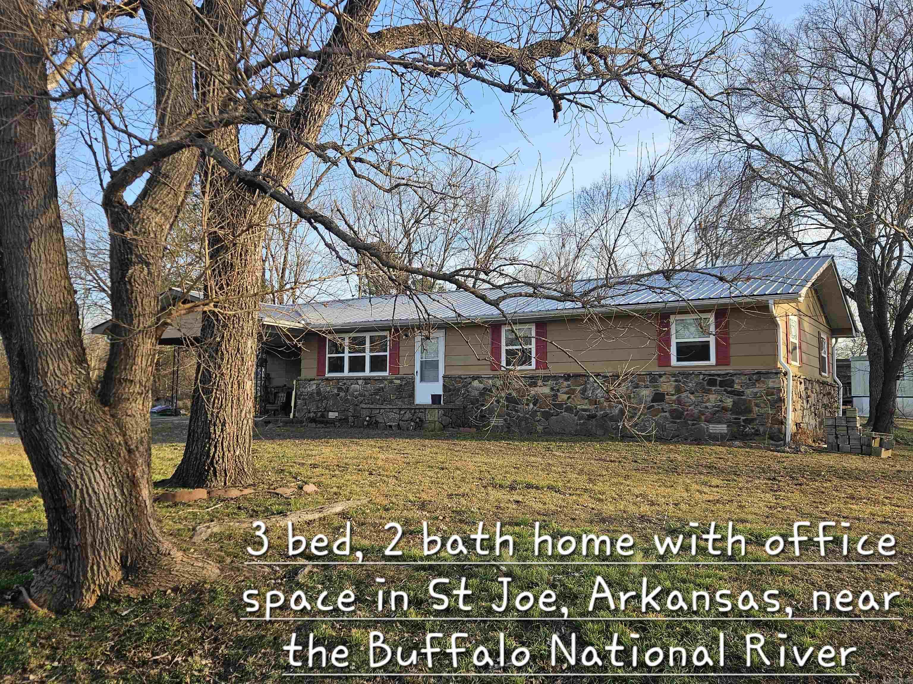 Right by the river in St. Joe, AR sits this move-in ready 3 bedroom, 2 full bath ranch with bonus office space and room to breathe. Located in an established neighborhood (no dirt roads) and just a short drive to Harrison or Branson, this one is all about convenience and possibility. Inside you’ll find a comfortable layout with space for family, guests, or working from home. Step out back to a large, pretty covered deck made for slow mornings and easy evenings. 2-car carport and storm cellar included. The property includes 1.5 lots and extra lot has septic already installed and rural water and electric available — build another home, set a trailer, or create extra income potential.Whether you’re looking for a full-time home or a nightly rental near the river, this one checks the boxes. Clean. Solid. Ready to go.