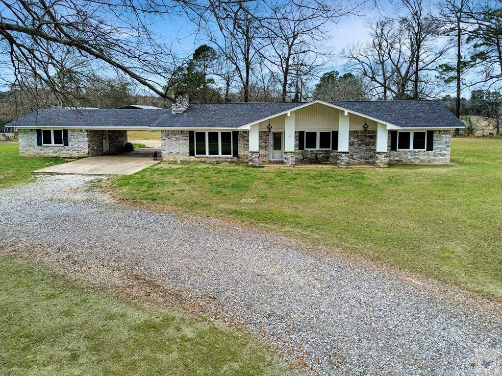 Discover the peaceful country lifestyle you've been dreaming of! Nestled in Fouke, AR within the sought-after Genoa ISD, this beautifully refreshed 1977 home sits on a 5 acre retreat, complete with an impressive workshop designed for your hobbies and projects. Step inside to find thoughtfully updated interiors showcasing fresh flooring, modern paint, and stylish light fixtures throughout. The heart of this home is the stunning kitchen, where a magnificent oversized island anchors the open-concept living space. Gleaming countertops provide abundant workspace, while the charming farmhouse sink adds timeless character. Picture yourself gathering with loved ones around the cozy fireplace on crisp evenings, natural light streaming through expansive windows that frame your private acreage. Three generously proportioned bedrooms offer comfortable retreats for the entire family. The primary suite boasts a spa-inspired bathroom with an elegant tiled walk-in shower and premium countertops. Guests will adore the vintage-inspired bathroom featuring a luxurious clawfoot soaking tub—perfect for unwinding after long days. The property's 20x50 insulated workshop with electricity.