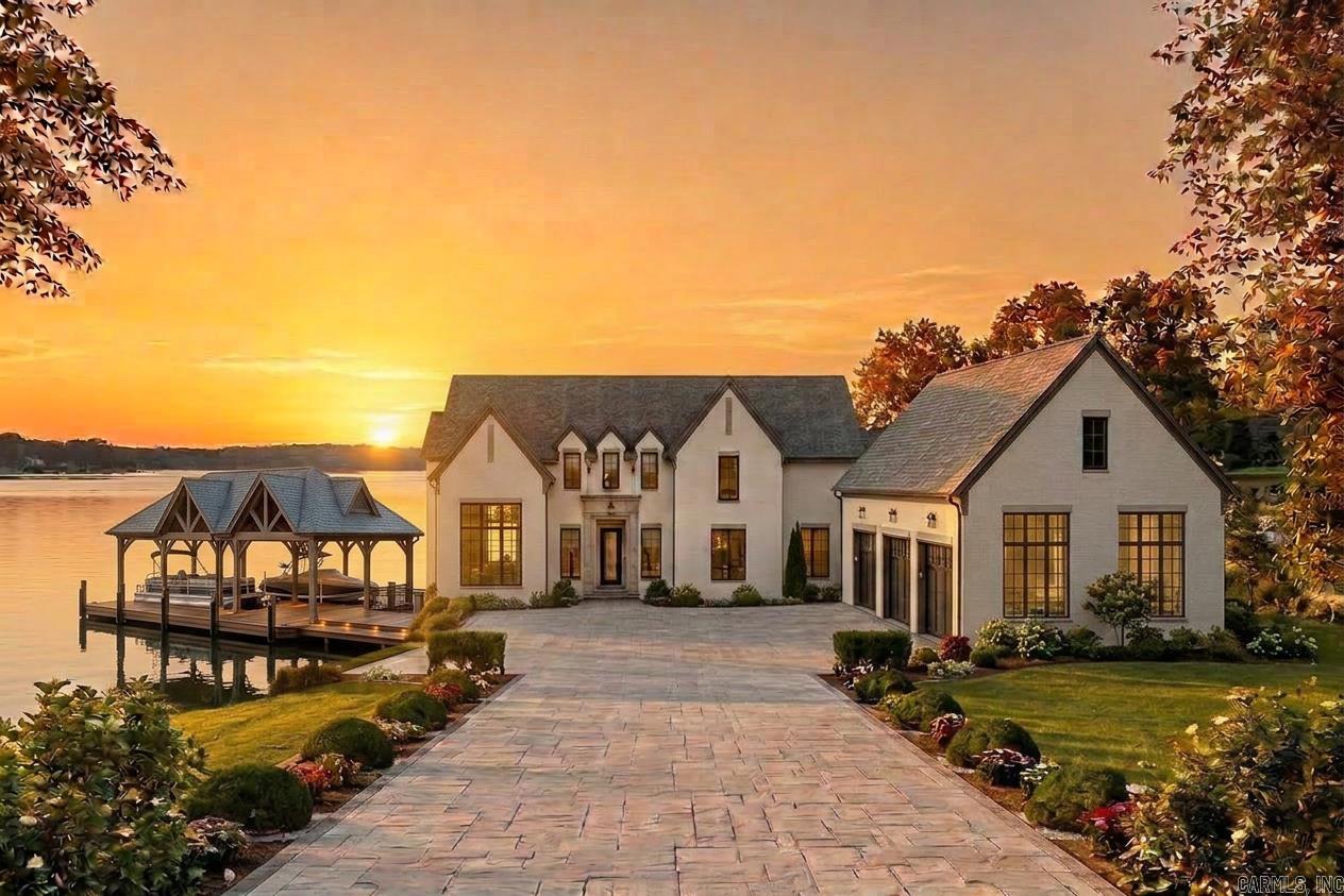 Proposed new construction by EY Custom Homes on Pennington Point, Lake Hamilton. This stunning 5,218 SF Transitional European residence designed by Tim Landreth Home Designs features 5 bedrooms, 4 full baths, and a half bath across two levels. Main level offers 10-ft ceilings, an open living area with two-story ceiling and stone fireplace, chef’s kitchen with gas cooktop, double ovens, butler’s pantry, and a hidden room. Luxurious owner’s suite with freestanding tub, oversized shower with bench, and walk-in closet. Covered porch with outdoor kitchen overlooks the lake. Upper level includes four additional bedrooms, a family room with vaulted ceilings, kitchenette, laundry, and generous storage. Dock with two covered boat slips. Office, built-ins, and thoughtful details throughout. Bring your buyers to Pennington Point — Lake Hamilton’s finest address. (3 1/2 acres available for additional cost!)