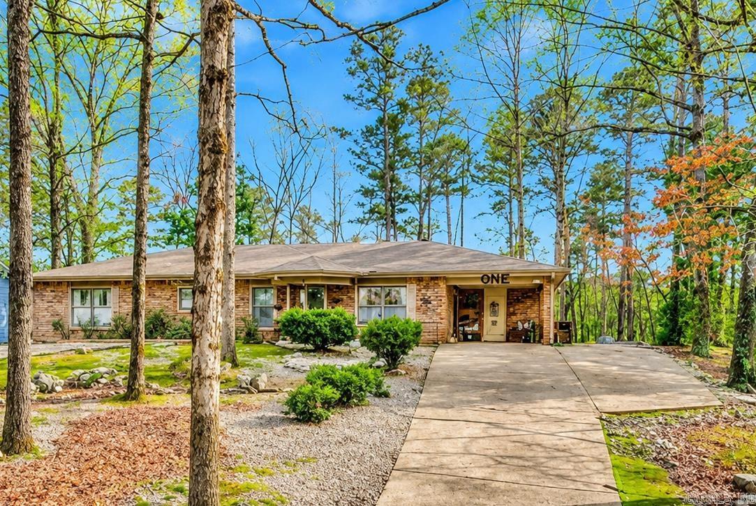 Welcome to 1 Montserrat in beautiful Hot Springs Village — a fully updated retreat tucked among the trees with the perfect blend of privacy, comfort, and convenience. This charming all-brick 2-bedroom, 2-bath home has been thoughtfully renovated with nearly every major system replaced within the last two years, including the roof, gutters, HVAC, water heater, appliances, lighting, carpet, and storm doors — giving buyers true peace of mind and move-in-ready living.   Inside, natural light pours through large windows and a skylight, creating a warm and inviting atmosphere. The spacious living area features custom built-ins, while the versatile sunroom with private carport entry offers endless possibilities as a third bedroom, office, hobby room, or cozy retreat. The primary suite is designed for relaxation with dual walk-in closets and a beautifully updated curb-less custom shower.   Step outside to enjoy the expansive deck and gazebo overlooking peaceful common property — the perfect setting for morning coffee or evening entertaining. Additional storage space and a covered carport with storage room complete this exceptional property. Enjoy all the amenities of Hot Springs Village!