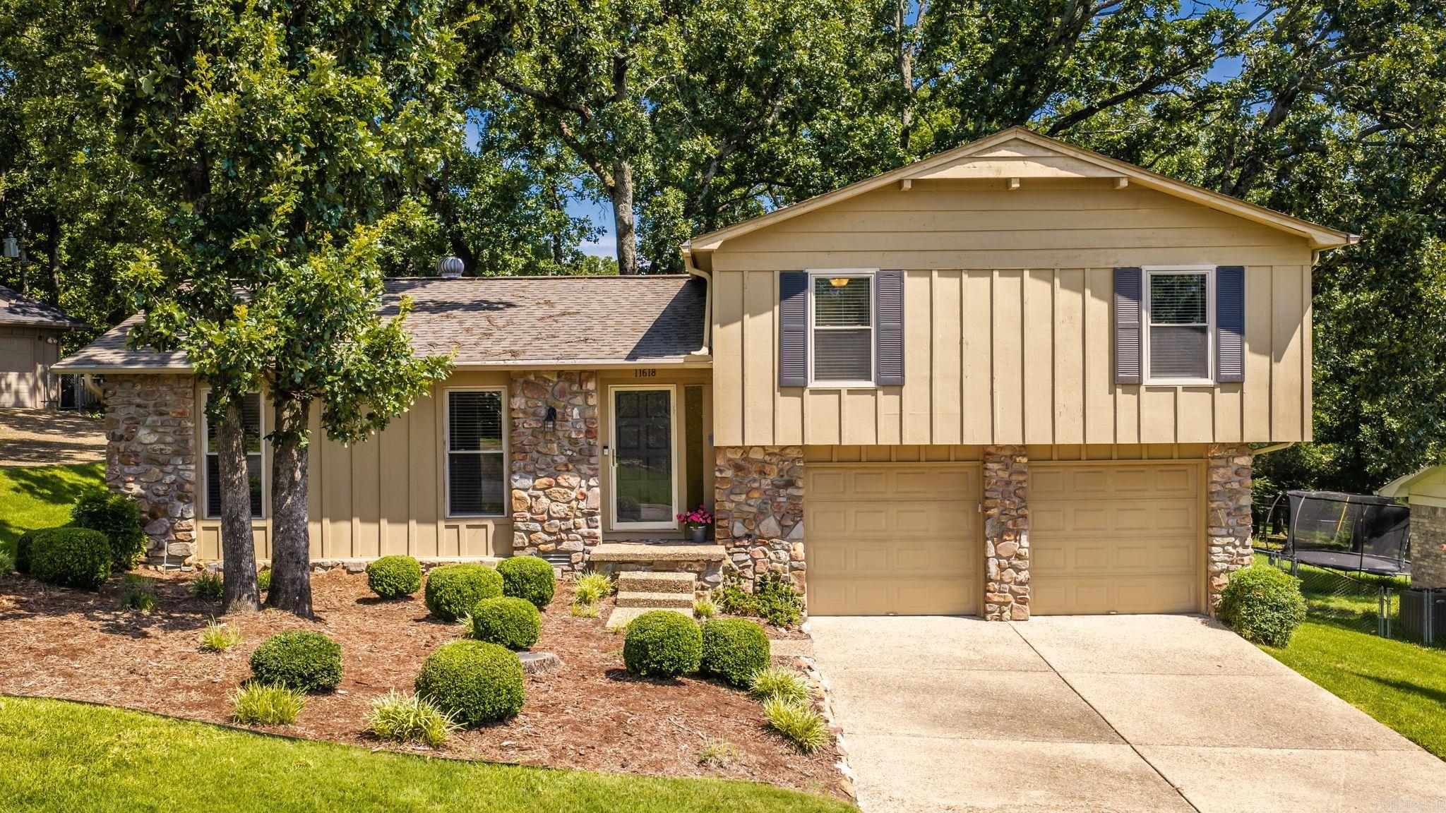 Welcome home to this charming three-bedroom tri-level set on a beautifully shaded lot. This well-cared-for property features an updated kitchen and bathrooms, neutral paint throughout, energy-efficient windows, and a bright, welcoming feel from the moment you step inside. The living room and formal dining combination showcases hardwood floors, while the spacious family room offers vaulted ceilings and a striking rock fireplace that creates a warm, inviting gathering space. The updated kitchen includes granite countertops, updated cabinetry, stainless steel appliances, and an eat-in area with a large picture window overlooking the backyard. Step outside to enjoy the back patio and shaded yard—perfect for relaxing, entertaining, or simply enjoying the peaceful outdoor setting. Additional highlights include a two-car garage with a large storage room that could potentially be air conditioned and used as an office, workout space, hobby room, or workshop. The electrical panel was also updated in 2023, adding extra peace of mind for the next owner.