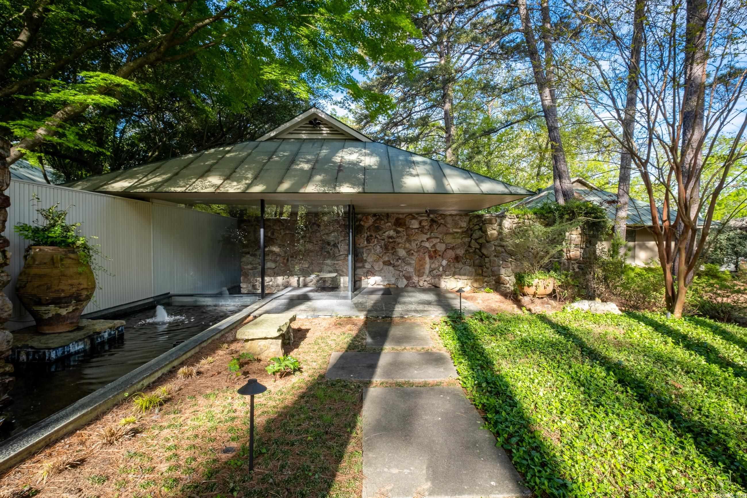A sophisticated custom designed contemporary on a large lot offering unexpected privacy.  The large floor to ceiling window blend the indoors with the outdoors.  This three bedroom home has been completely remodeled with a sleek kitchen with beautiful cabinetry,handsome white bathrooms, white pine floors, extensive indoor and outdoor entertaining areas and lovely landscaping.  Has a three car rear loading carport, new laundry, new HVAC, new flat roofing, exciting water features and much more.  A list of improvements is in booklet on kitchen counter.  It reminds you of a piece of art due to its design and composition.