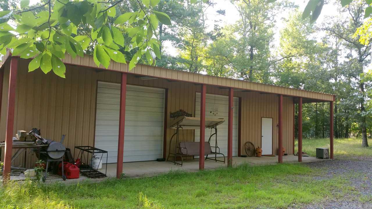 Perfectly lovely spot to build your getaway home or permanent residence.  Only  5 miles from town, yet tucked into this wooded 5.45 acres overlooking a small, clear water lake.  Wildlife abundant & fishing is sublime.  Shop has finished 1 bedroom, 1 bath living quarters, & is fully livable while you ride the National Forest ATV trails nearby or construct a new home. All utilities included: public water, power, & septic.  Satellite & Internet available. Propane Gas. No mobile homes.  Lake privileges.