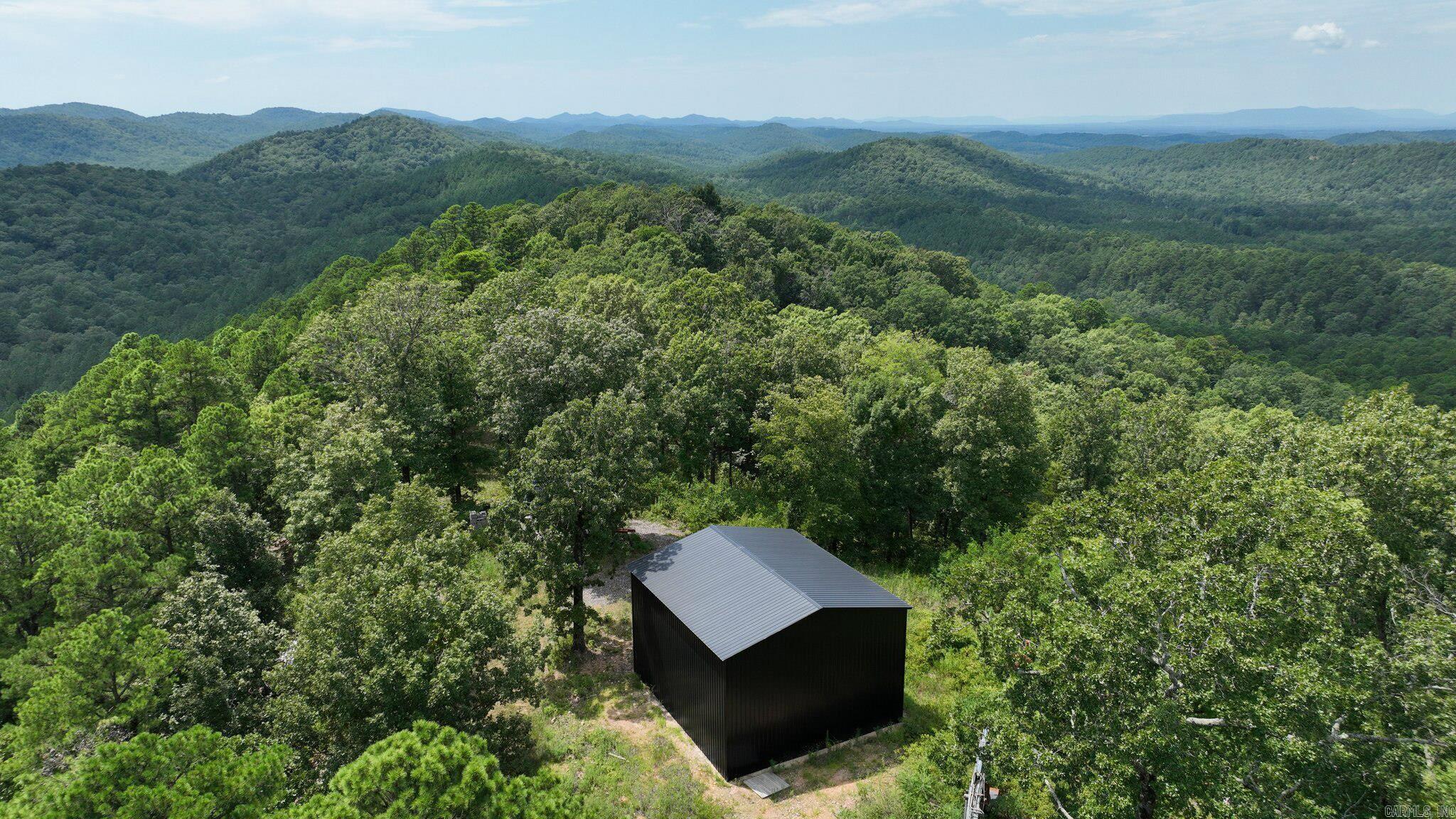 85.29 acres in the Big Fork area with three sides reportedly bordering the Ouachita National Forest, offering mountain scenery with elevated and vista-style viewpoints. The land includes a mix of rolling hills and wooded terrain that may support habitat for deer, turkey, bear, and small game, subject to buyer verification of wildlife use and any hunting regulations. Existing improvements are reported to include a water well, on-site power, an internal road, two unfinished outbuildings, and a prepared cabin site; buyers should inspect and confirm condition, capacity, and permitting for all utilities and structures. The location provides access to nearby Wolf Pen Gap ATV trail systems and the opportunity to create private riding and hiking paths on the property, depending on any applicable use or forestry restrictions. This tract may work well for buyers seeking a private recreational, hunting, or cabin site within driving distance of Mena; all boundaries, acreage, access, and intended uses should be verified with the appropriate authorities.