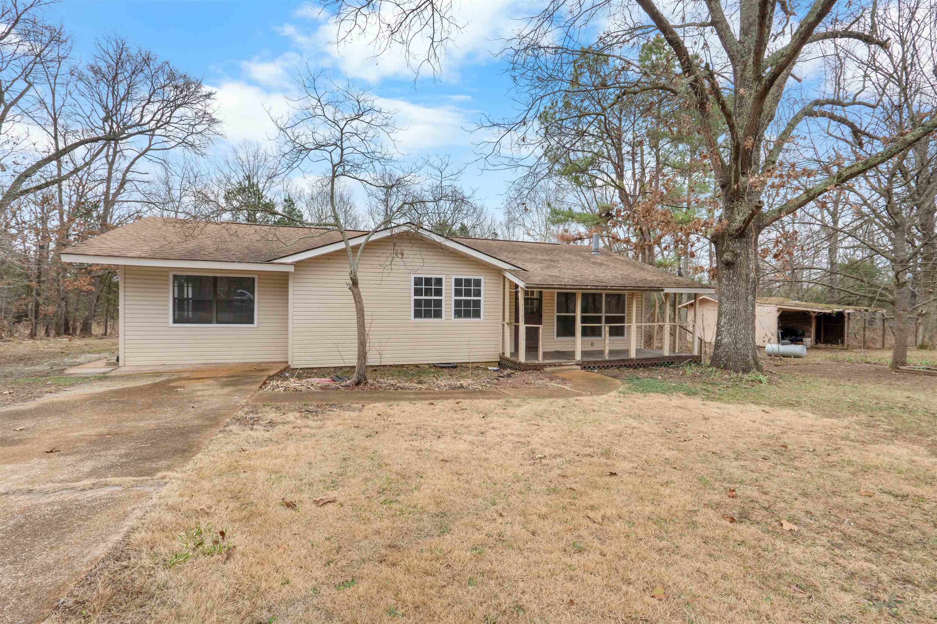 3 bedroom, 1.5 bath home sitting on two lots in a private setting with paved road access. The home features a comfortable living area and a great size kitchen and walk-in pantry offering tons of storage. A den or family room adds extra living space and connects to the primary bedroom, which includes a half bath and direct access outside to a covered area. A storage building is located on the property, providing even more space. The home has had several updates including new flooring, paint, updated fixtures, & more! Great home at an affordable price!