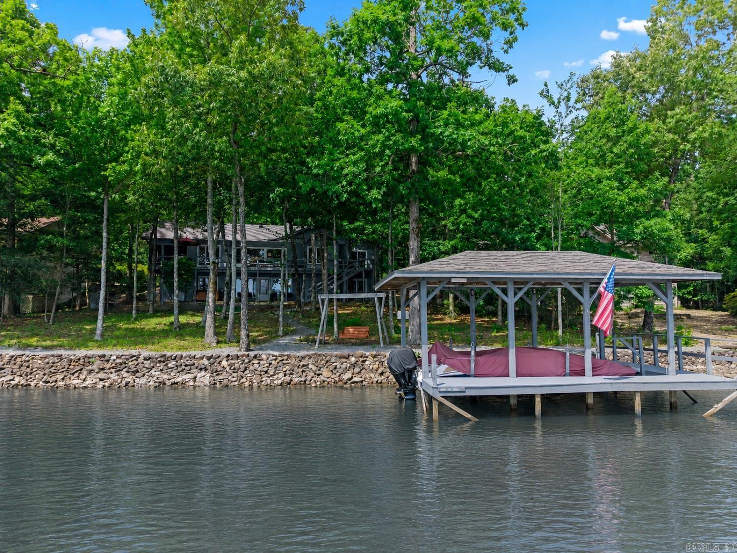 Aprox.145' of Lake Balboa WATERFRONT! Enjoy panoramic views and low-bank lake living from this charming 3,173 sq ft home on HSV's largest lake! The 1902 sq ft main floor with Primary Suite, Guest Room and additional Bedroom/Den has that "WOW factor" with walls of windows and an Entertainment-sized Deck overlooking the lake! The Living Room boasts Cathedral Ceilings, Brick Wood-burning Fireplace, and Built-ins with included surround sound stereo system. The  Primary Bedroom with Walk-in Closet, Ensuite with Jetted Tub and Slider to the Deck will surely spoil you! The Granite Kitchen with Skylight and Alder(?) Cabinetry is open to the Bright Eating Area and adjacent Screened Porch. A large laundry room and 2 Car Garage with specialty flooring complete the main floor, but wait.... The 1271 sq ft basement includes a 22x21 shop (heated & cooled) with a commercial air filtration system, a 21x21 Rec Room and another Guest Room with Walk-in Closet + Guest Bathroom! An outdoor storage room for lake toys, a quality Hot Tub and Boat Dock w/Lift complete this special property! NEW ROOF GOING ON THIS WEEK! Don't miss the attached VIDEO TOUR!