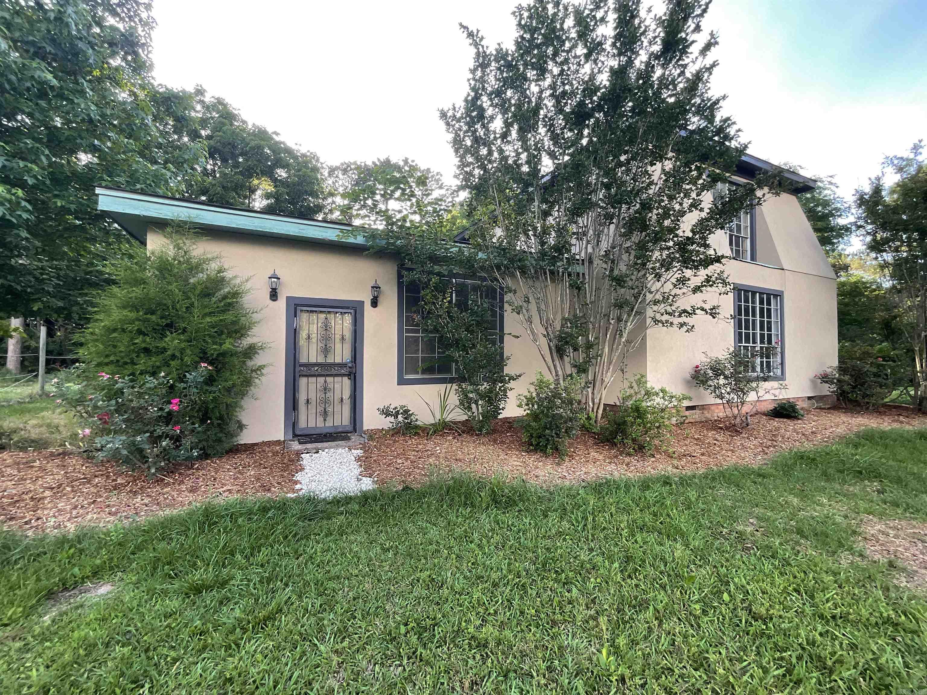 Bring your homesteading dreams to life with this unique country property! With a spacious home, hardwood floors, oversized bonus room, galley kitchen, and large dining/entry area off the back carport, there’s plenty of room to live, work, and grow. Recent updates include fresh downstairs paint, a remodeled upstairs bathroom, and a brand-new roof and exterior stucco in 2025. The 24'x30' insulated shop offers space for hobbies, vehicles, and storage while the oversized stall to the back (15'x30') back is perfect for horses or livestock, complete with a tack room. The shop has electric run through metal conduit for added durability. Originally set up for horses, the property features over 2 acres of fenced pasture with a convenient walkthrough passage connecting the front and back acreage. Mature trees surrounding the property create a peaceful, private country setting. SEE AGENT REMARKS!