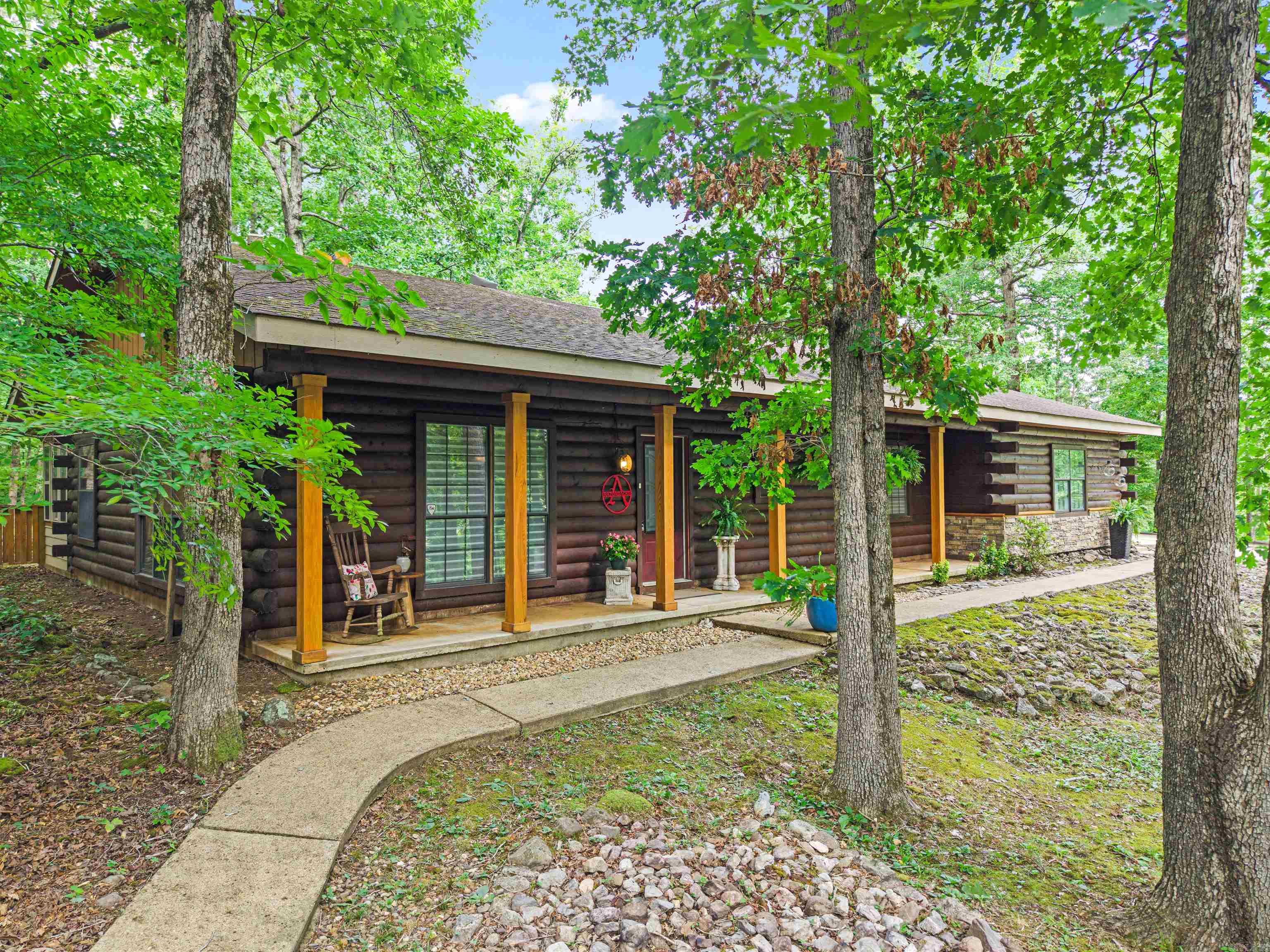 Charming 3 bedroom 2 bath CYPRUS LOG home in Jessieville School District ONLY 8 MILES FROM THE LAKE OUACHITA launch ramp at NorthShores Marina! Updated, Loved, & Well-taken care of is what you will feel as you drive up the concrete driveway & step into this beautiful home.  Sun lighting up the roomy living room is cozy and inviting while real hardwood floors comfort your bare feet. Past the dining room, is the windowed den for enjoying morning coffee or conversing with friends & family.  Preparing meals is easy in the well-appointed kitchen with space to move, ample cabinetry/countertop space, & slate tile floors. Grass-cloth adoring the walls adds even more character to the already delightful home! The hallway nook is the ideal place for your home office. Down the hallway, the spacious primary ensuite with a sitting area for lounging & a large walk-in shower is the perfect place for rest and relaxation. 2 guest bedrooms provide space for family and guests. The garage is oversized with additional storage space. The circular drive through the carpet makes boat storage a breeze & the second garage is home for your ATV! End the day with a cold drink on the covered porch! Agent Remarks