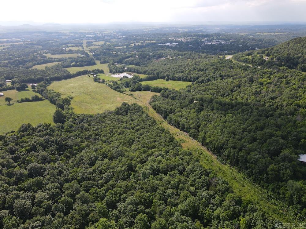 Located just minutes from Marshall, Arkansas, this beautiful Ozark property offers a rare combination of privacy, convenience, and development potential. Featuring a mix of mature hardwood timber and productive pastureland, the gently rolling terrain is ideal for a private estate, multiple homesites, or future development. The open ground has historically been used for hay production and provides excellent usability. City water and electricity are already on site, making this one of the area's most build-ready opportunities. Less than a quarter mile off pavement, the property offers easy access while maintaining a secluded feel. Elevated areas provide the potential for stunning western sunset views and numerous scenic building locations.