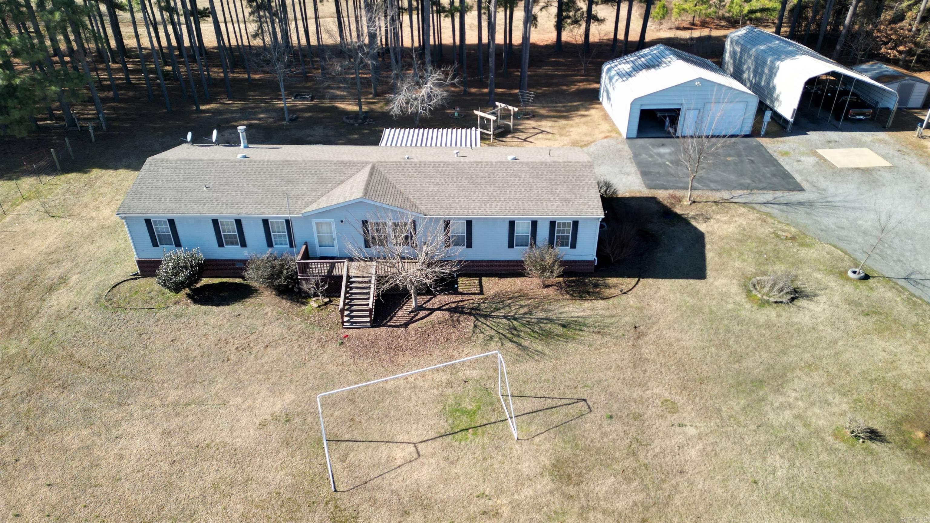 Take a look at this beautiful piece of property.  The mobile is a doublewide with 4 bedrooms and 2 bath. Primary has its own sitting area/office space. Primary bathroom has a wonderful soaking tub along with a separate shower and a large walk in closet. Home has a large living room and a large separate den with a wood burning fireplace. The land is gorgeous! Lots of open areas and a large pond with a dock to enjoy a peaceful day of relaxation. There are 3 separate deck areas off the back of the home and one is screened in so you can enjoy your evenings on your back deck with no bugs! One area is set up for you to have your own pool if you choose to do so! Property also includes a 30X30 Utility building, small storage shed, double carport, a chicken coop, a large dog pen, and a storm shelter. Come check out this little piece of heaven in a high demand area! It won't last long, don't miss out!!