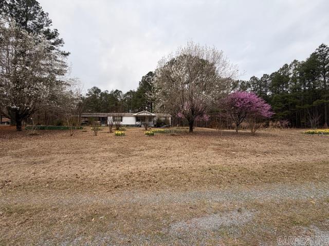 Charming country property on 7.41 acres in Louann, AR! This 1,560 sq ft manufactured home, built in 1999, offers 3 bedrooms and 2 bathrooms with plenty of potential to make it your own. While the interior could use some updates, the setting is truly special—featuring 3.68 wooded acres that could serve as an additional homesite or private retreat. The land is dotted with blooming daffodils and other beautiful flowers, creating a peaceful, scenic atmosphere. A shop and storage shed provide added functionality for hobbies or extra storage. Great opportunity for those seeking space, privacy, and potential in a rural setting. Square footage, lot size, and acreage is taken from courthouse records.