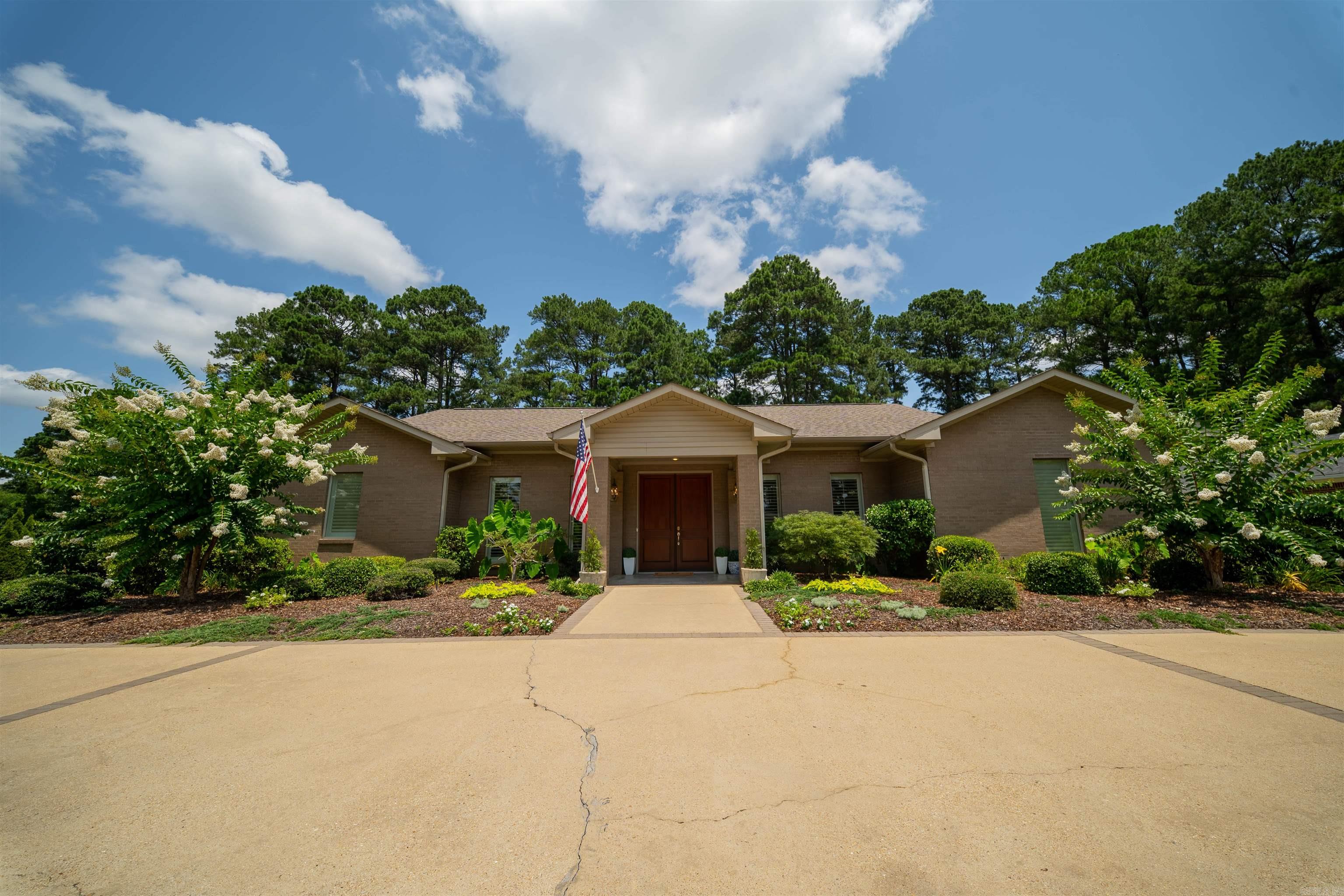 Welcome to 410 Hazel Circle, a beautiful custom-built home tucked away on a quiet circle in Magnolia. This inviting two-bedroom, two-and-a-half-bath home offers approximately 3,146 square feet with a warm, comfortable layout, large rooms, great natural light, and a wonderful sense of privacy.One of the home’s standout features is the living room with its high vaulted ceiling, hardwood floors, expansive windows overlooking the patio, and a gas fireplace, creating an open, airy feel with architectural character and warmth. The spacious living room, large rooms, and comfortable kitchen and dining areas make this home wonderful for entertaining family and friends, while still feeling cozy for everyday living. Designed with both comfort and function in mind, the home also features ample storage, two utility rooms, a butler’s pantry, and generously sized bedrooms. Outside, the property offers a peaceful, scenic backyard with mature surroundings, a welcoming patio area, and an outdoor gas fireplace to enjoy year-round. The circle drive adds convenience for guests and provides nice curb appeal.  For your private showing call Linda Anders at 870-234-0147.