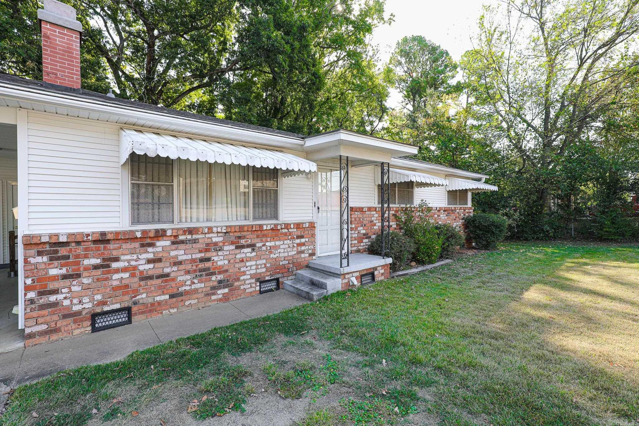 Welcome to 514 N Cox St., a beautifully maintained 3-bedroom, 1.5-bath gem located just steps from Benton Jr High. This home boasts timeless charm with a beautiful stone fireplace, and original hardwood floors preserved beneath the carpet in the living room, bedrooms, and hallway. Recent updates include a brand-new roof and newer HVAC package unit and water heater, ensuring worry-free living for years to come.  Step outside to a spacious, covered back porch, perfect for entertaining or relaxing year-round. Additional storage space is conveniently accessible from the carport, adding to the practicality of this inviting home.  Agents please see remarks