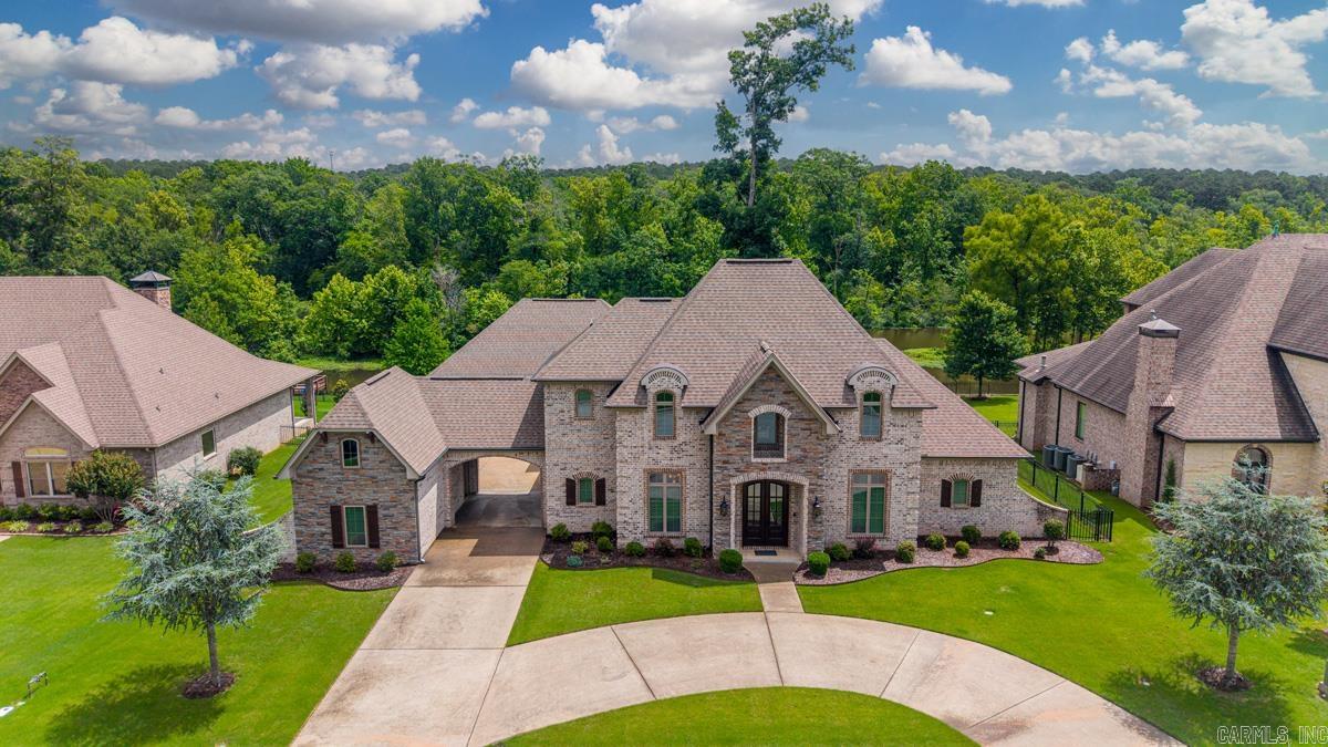 Welcome to your lakefront retreat - an exceptional estate designed to impress at every turn. The stunning curb appeal & manicured grounds set the tone for the luxury that awaits. Step through the front door & be greeted by soaring ceilings, abundant natural light, & breathtaking lake views. The chef’s kitchen is a true showpiece, featuring double ovens, gas range, oversized entertainer’s island w prep sink, & ample space for gathering w guests. The spacious primary suite offers a private sanctuary complete w a spa-inspired bath featuring a soaker tub, walk-in tile shower, double vanities, & an expansive walk-in closet. The main level also includes a guest suite w private bath & a beautiful office w custom built-ins & panoramic water views—easily serving as a 5th bed if desired. Upstairs, you’ll find 2 additional beds & full bath, providing plenty of space for guests. Outside, enjoy the covered patio, charming pergola, & expansive, waterfront backyard. Additional amenities include a porte-cochère, 220V EV charger, 22KW Generac generator, sprinkler system, oversized two-car garage, a separate third garage/shop space w epoxy floors & private dock. You must see this one for yourself!
