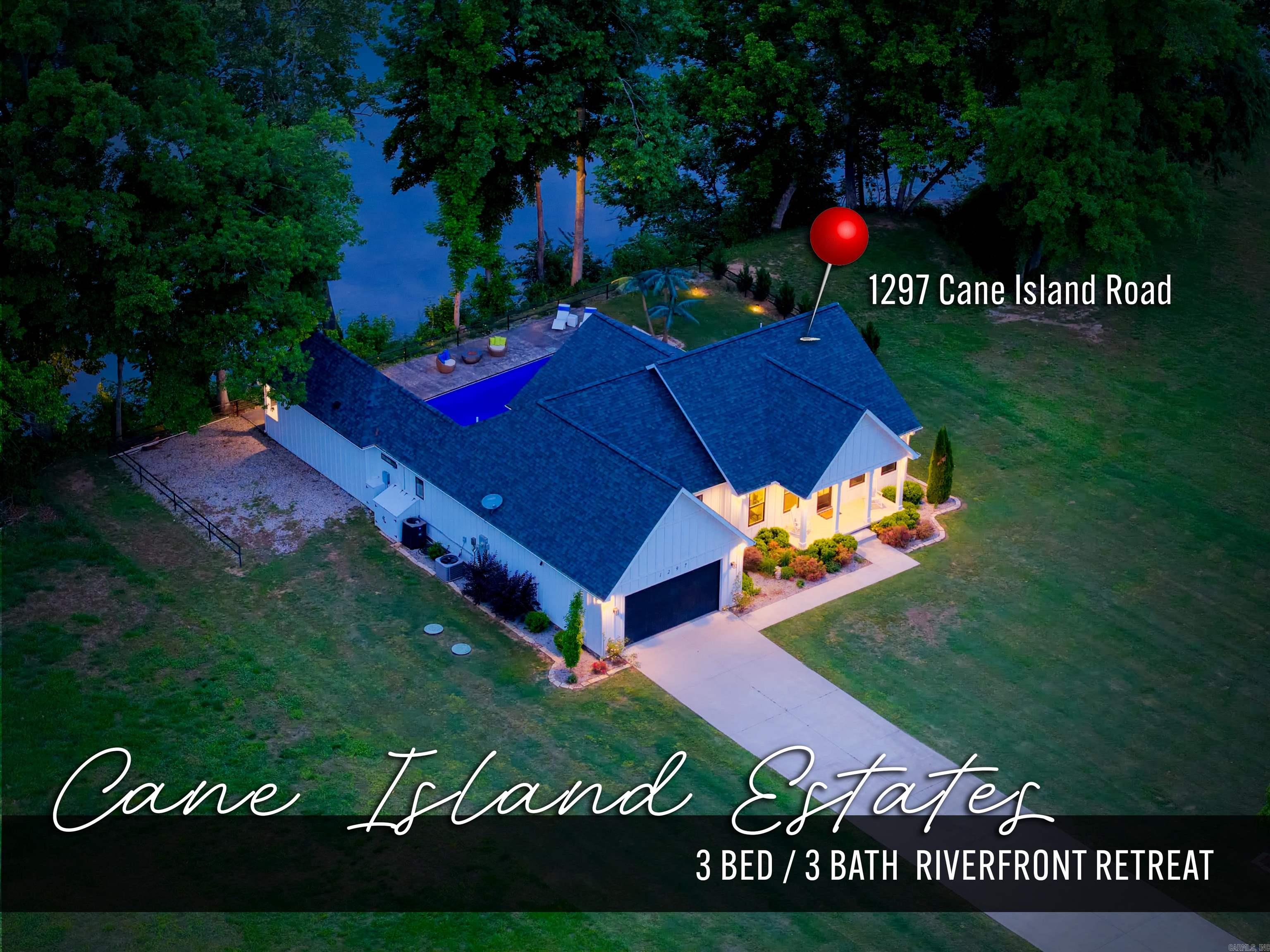 Your dream riverfront retreat is on the market! Take in beautiful White River views from your covered slate patio and heated saltwater pool with tanning ledge and auto cover. The fully equipped outdoor kitchen showcases granite countertops, a grill, griddle, beverage cooler, bar seating, outdoor TV, and a propane fireplace. A conveniently located bathroom with direct access to the pool area adds functionality. Built in 2022 and selling fully furnished, this exceptional 3BR/3BA home is located in a private, gated community Cane Island Estates is situated across from Gaston’s White River Resort & Restaurant. Thoughtfully designed with a split-bedroom floor plan, the home offers open-concept living & dining, a butler’s pantry, and a dedicated laundry room. Exterior features include classic board-and-batten siding and beautifully maintained flower beds, 2 car garage, covered front porch with stunning bluff views and access to the community boat ramp, included with the $800 annual association fee.