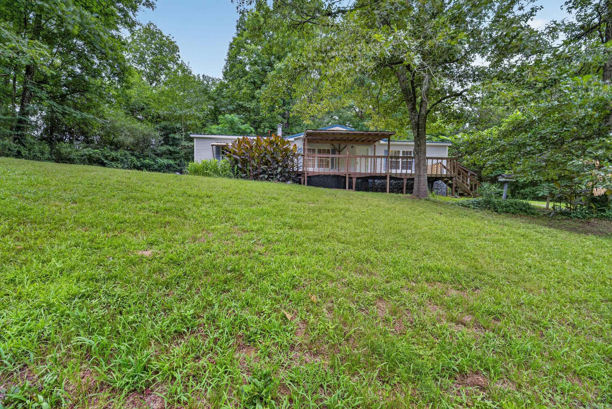 Looking for a secluded property with room to breathe? Nestled on approximately 2 acres in Pearcy, Arkansas, this 3-bedroom, 2-bath mobile home offers the privacy and peaceful setting that so many buyers are searching for. Surrounded by nature and tucked away from the road, this property provides a rare opportunity to enjoy country living while remaining within easy reach of Hot Springs and area lakes.  The home is livable and functional but could benefit from updates and improvements, making it an excellent opportunity for buyers looking to add their own personal touch, investors seeking their next project, or anyone wanting affordable acreage in a desirable location. With plenty of usable land, there's room for outdoor entertaining, gardening, recreation, additional structures, or simply enjoying the quiet surroundings.  Whether you're looking for a primary residence, rental property, weekend getaway, or investment opportunity, this property offers the chance to build equity while enjoying the privacy of rural Arkansas.