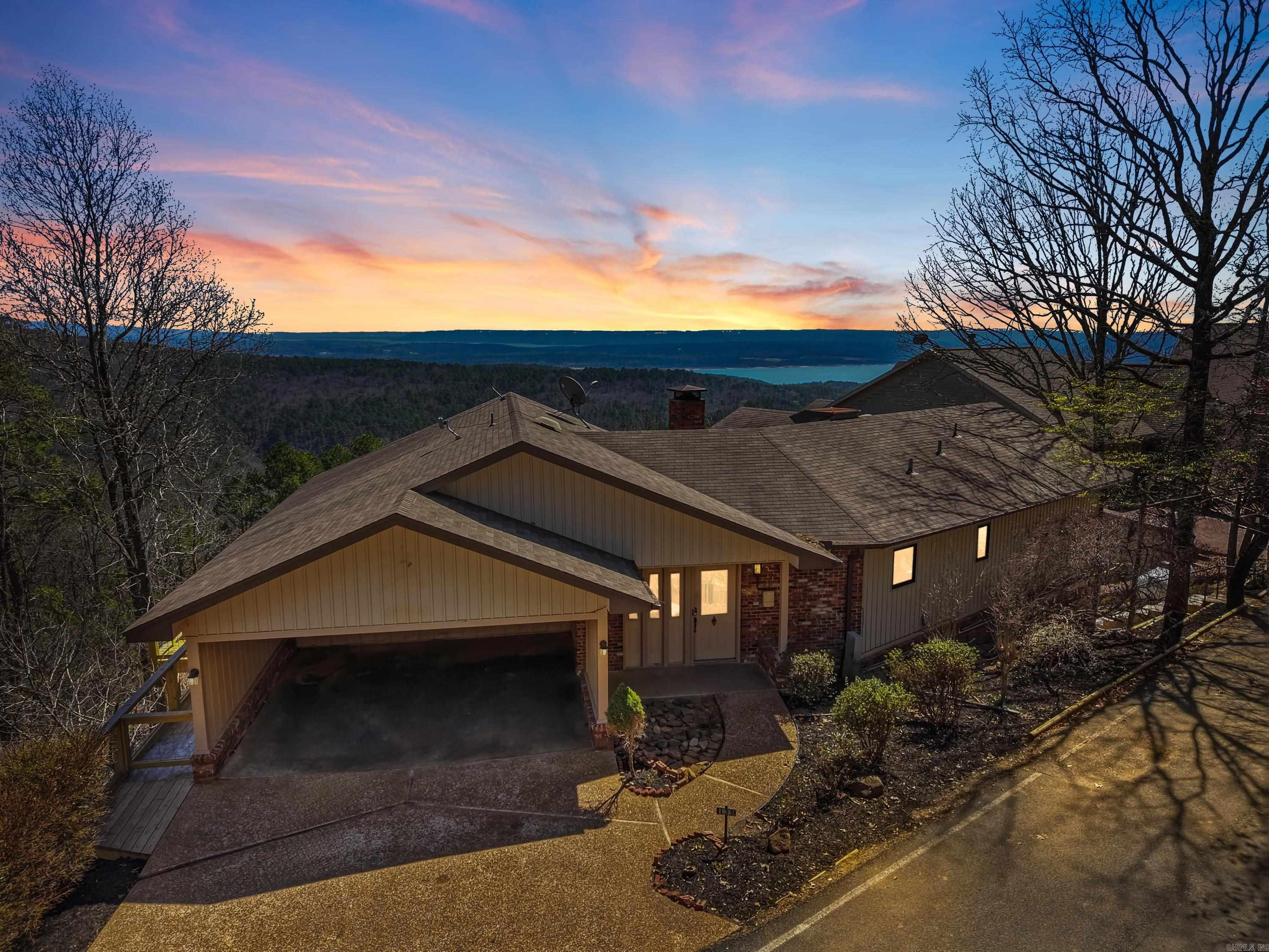 Wake up to breathtaking lake & mountain views, where every sunrise paints the sky & every moonrise feels like a private show. Designed by a well-known  architect, this special home was created to celebrate its incredible setting, with a soaring wall of windows that fills the interior with natural light & brings the outdoors in. Inside, you’ll find luxury vinyl plank flooring, new quartz countertops & backsplash, some newer appliances, new electric sun shades, & the peace of mind of a NEW whole-house generator. The sunroom is the perfect place for morning coffee or quiet evenings, while the expansive newer deck invites you to relax, entertain, & soak in the beauty all around. Terraced garden areas add charm & color, the lower level offers a large workshop, plus abundant storage with sturdy poured concrete walls. Just a short walk to the cool pool, pickleball, tennis, & other Fairfield Bay amenities, with Greers Ferry Lake, 2 golf courses, hiking trails, & ATV trails nearby. Whether you are hosting friends or enjoying a peaceful retreat, this home offers comfort, beauty, & the kind of views that make every day feel like a getaway. It truly feels like a sanctuary. See agent remarks.