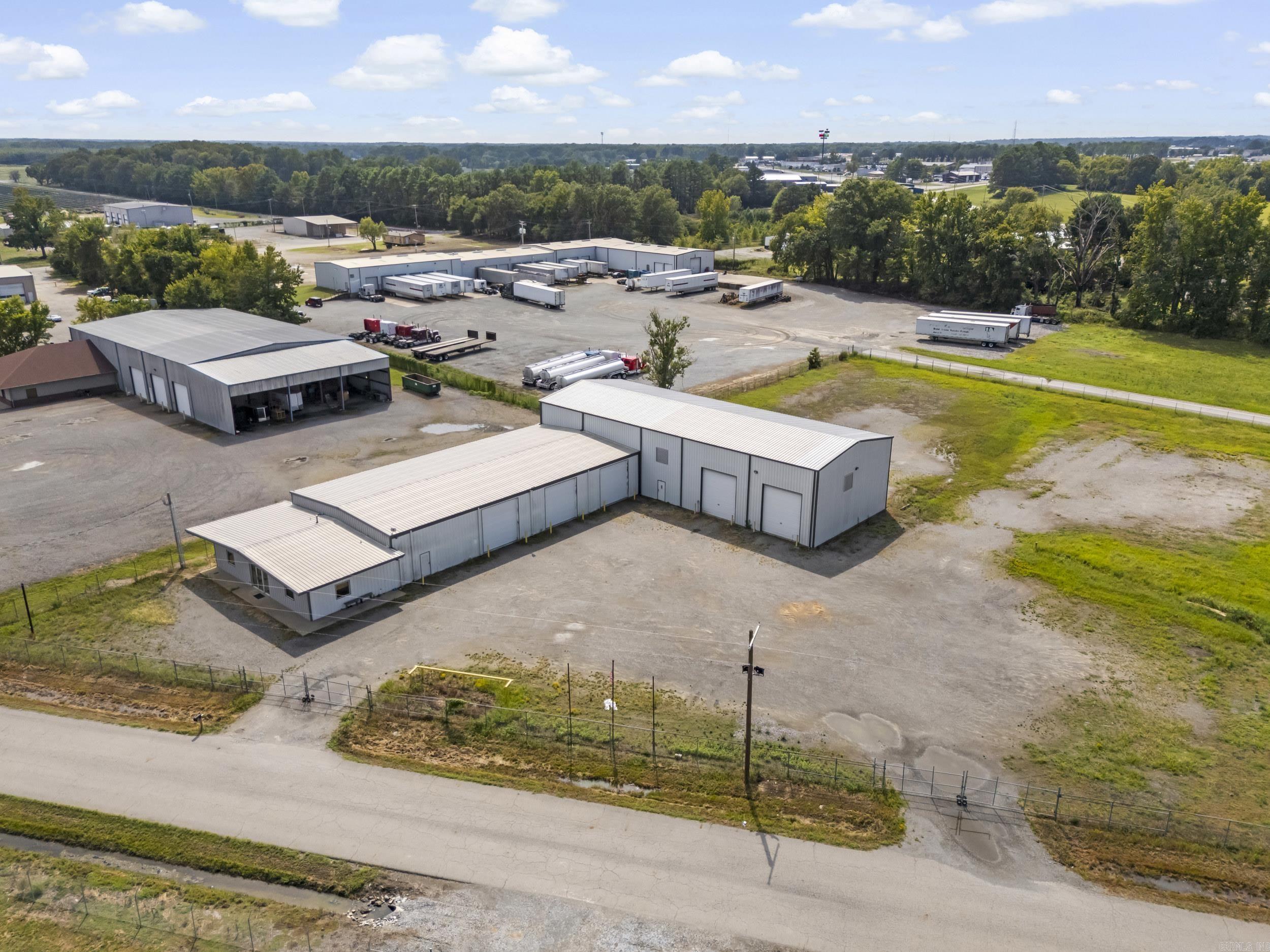Fabulous new listing with unlimited possibilities for the space. 11,650 sq feet of work area plus lockable housed air compressor unit room.  1,000 sq ft of high end central heat and air office space with stained concrete flooring, private bathroom with shower area in office space. Fully furnished break room, full safe room with 6 " thick door.  3 phase electrical service.  10 ton power trolley bridge crane, wash bays with oil and water separator.  Heavily graveled lot with 4 entrance/exits for 18 wheeler traffic.  Three 14' tall power lift doors, four 16' tall drive through bays with power lift doors.  Shop area has multiple synchronized control power louvers and 5' cross ventilation fans.  Infrared heaters throughout.  Multiple 220 outlets , one three phase outlet, multiple air drops, and 110 outlets throughout.  Easy on and off Hwy.  67-167 exit and sitting on city limit boundary, just outside of city limits.