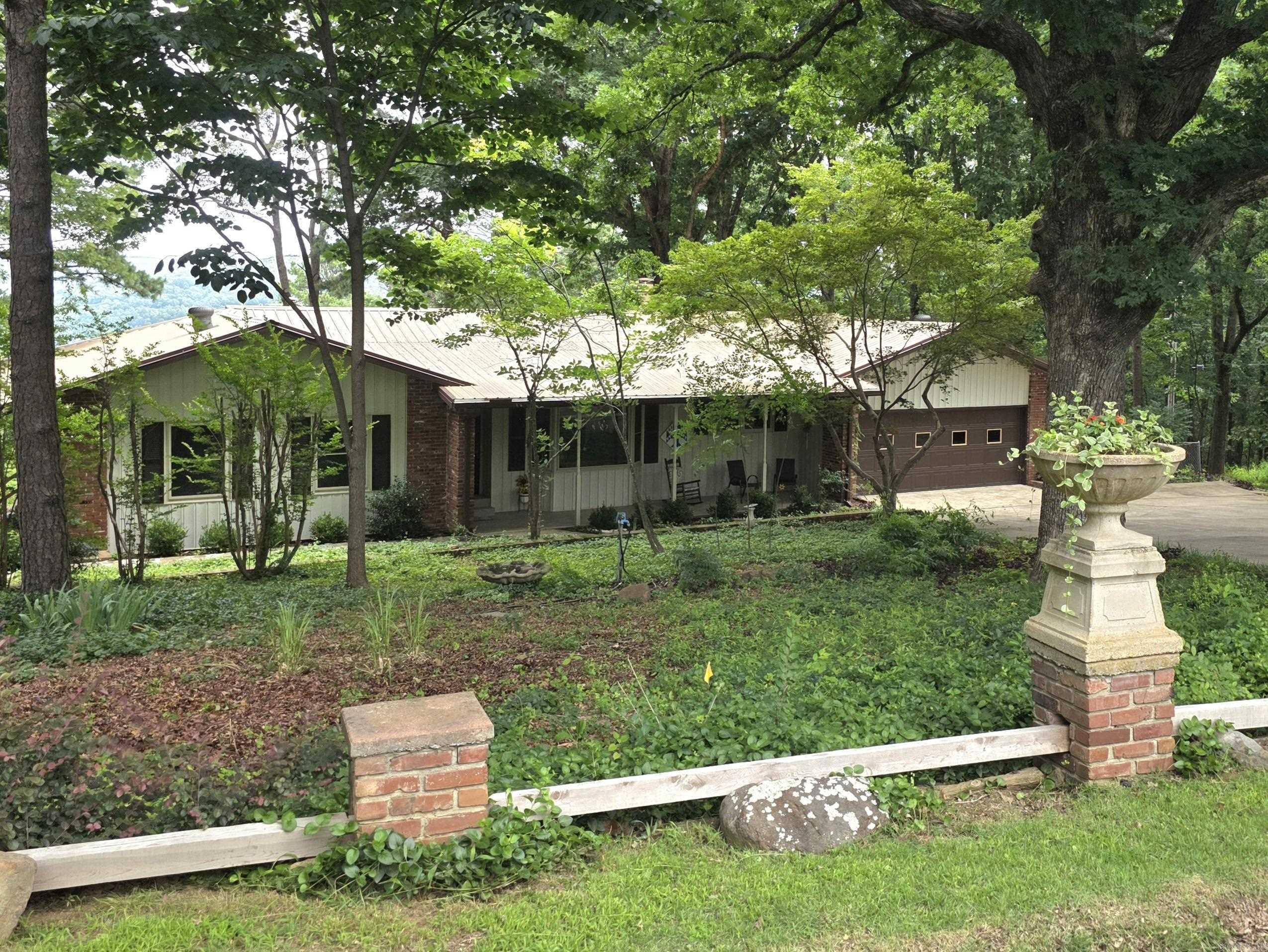 Custom-built, Ozark Mountain home with a stunning view overlooking Heber Springs; close to Greers Ferry Lake and the Little Red River, famous for trout fishing. Large wooded lot in a quiet neighborhood convenient to Hwy 25. This home was designed to enjoy the outdoors with a spacious covered front porch and a sun room leading to a large wrap around deck great for entertaining and enjoying the fabulous view. Oversized 2 car garage perfect for crafters or a home business: gas heater, built in work bench, sturdy 2x4-6 shelving, and a wall of pantry cabinets. There is a safe room that can also be used for storage, utility building, and a fenced area with doggie door. You must see this home to appreciate all the amenities and up-dates: on demand hot water, full masonry fire place with a gas log, built-in cabinets and book shelves, newer Samsung appliances that stay, thermal Alaska windows, metal roof, solid oak flooring, security system, and an over-sized utility room with extra cabinets and a walk-in pantry