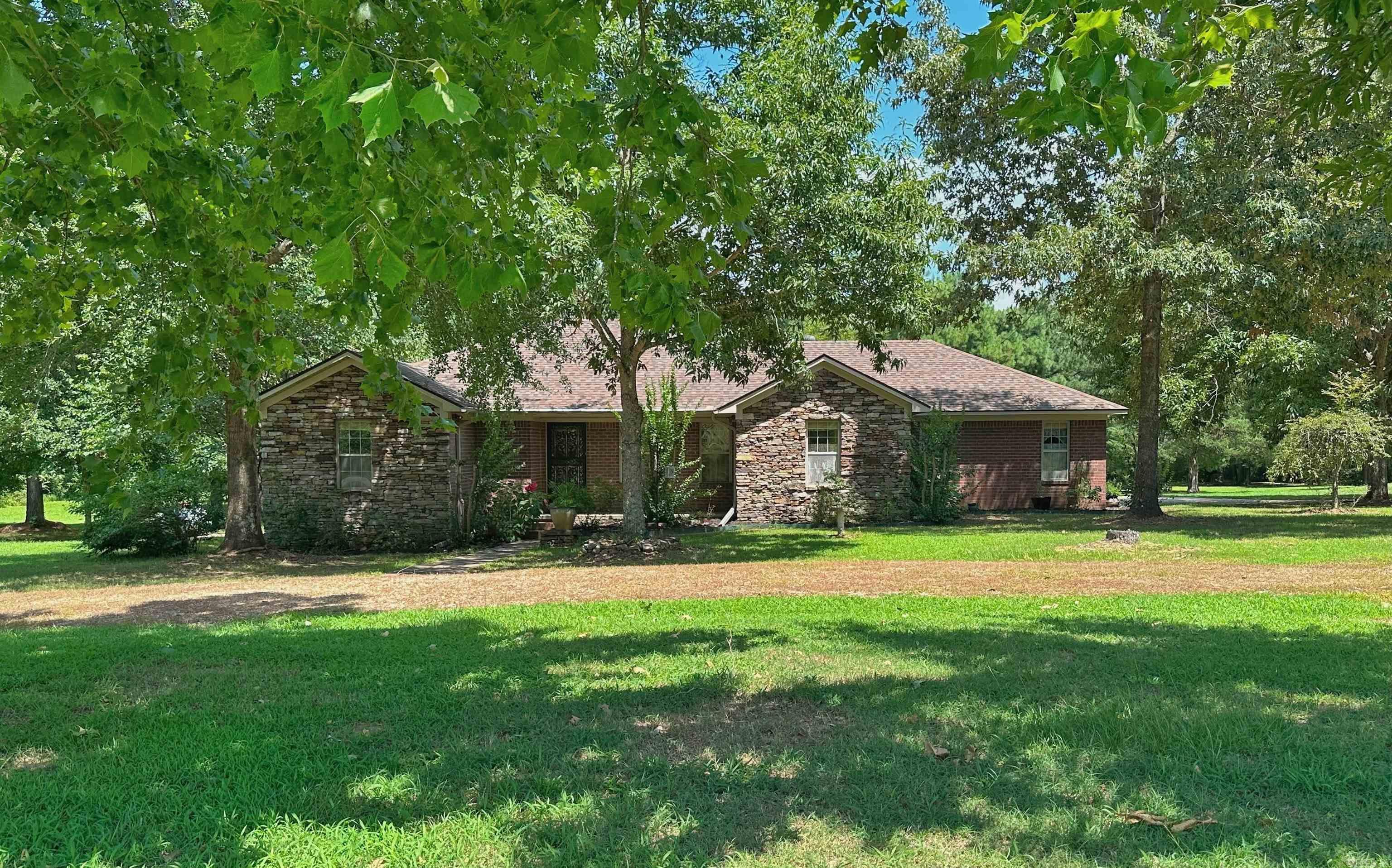 Country Living at Its Best | 25.27 Acres | Pond, Shop, Boat Garage, Generator & Hunting Land  Enjoy the perfect blend of comfort, privacy, and recreation in this beautiful 3BR, 2BA brick and stone home on 25.27 acres in the Quitman School District. The 2,291 SF home features hardwood and tile floors, crown molding, built-ins, wood-burning stove, 300 SF sunroom with fireplace overlooking the pond and scenic acreage and a spacious deck for enjoying wildlife and peaceful country views.  The custom eat-in kitchen offers solid wood cabinetry, rollouts, double ovens, and a breakfast nook. The private primary suite features an architectural ceiling, walk-in closet with safe, double vanity, oversized jetted tub, and separate shower.  Exterior features: 3-car garage with underground storm shelter, new roof (2022), new heat pump (2023), Generac 28KW whole-house generator, boat garage, insulated shop, 50-amp RV hookup, pond, zero-turn mower, excellent deer and turkey hunting, plenty of room for a pool and a garden!   Well-located near Heber Springs, Greers Ferry Lake, the Little Red River, and fruit orchards. Owner's pontoon and river boat are available separately to make your move complete!