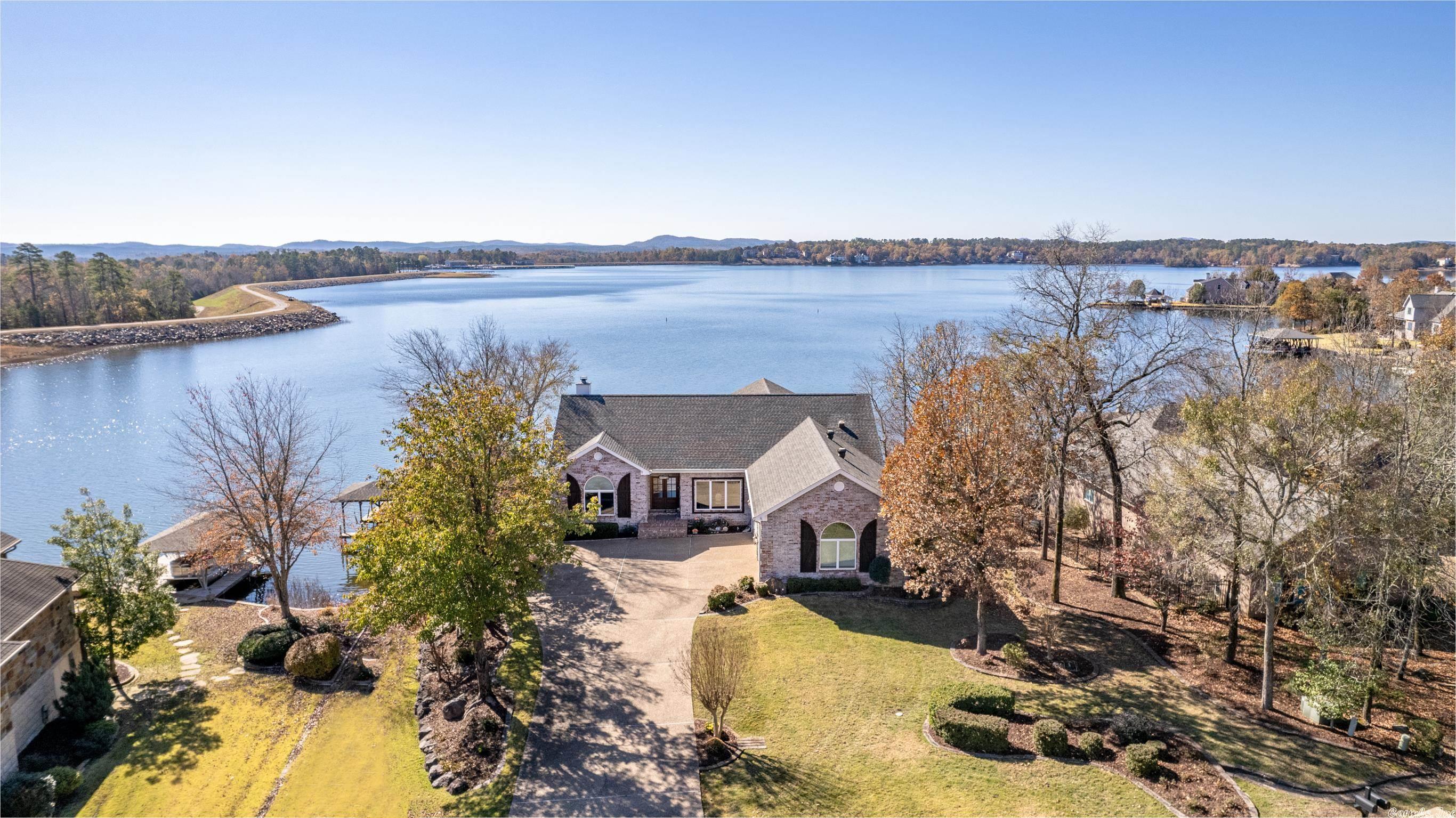 UNBELIEVABLE LAKE BALBOA VIEWS! Custom home on premium, level to lake, and fully landscaped lot with expansive views of water, mountains, marina, beach, and natural walking trail! Experience Balboa's best view for July 4th fireworks! Main level features formal living and dining rooms along with main and guest bedroom. The well-appointed kitchen overlooks the breakfast area, Arkansas Room, and walls of tinted glass for view enhancement and UV protection! For maximum view enjoyment, the Main bedroom suite can be accessed from the AR room or front hallway! Don't miss the screened porch! The custom designed laundry room boasts plenty of storage, sink, and access to the oversized garage...also with loads of storage! The lower level features an office space, spacious guest suite with bathroom close by, and a 4th room for a bedroom, media room, den, crafting, your choice! Be SURE to check out the crawl space that is fully level and concreted space for storage or additional multipurpose space! Access the grand covered patio, walkways, and covered boat dock from the lower level as well! Call today for your personal tour and learn more about what this home offers! See agent remarks.