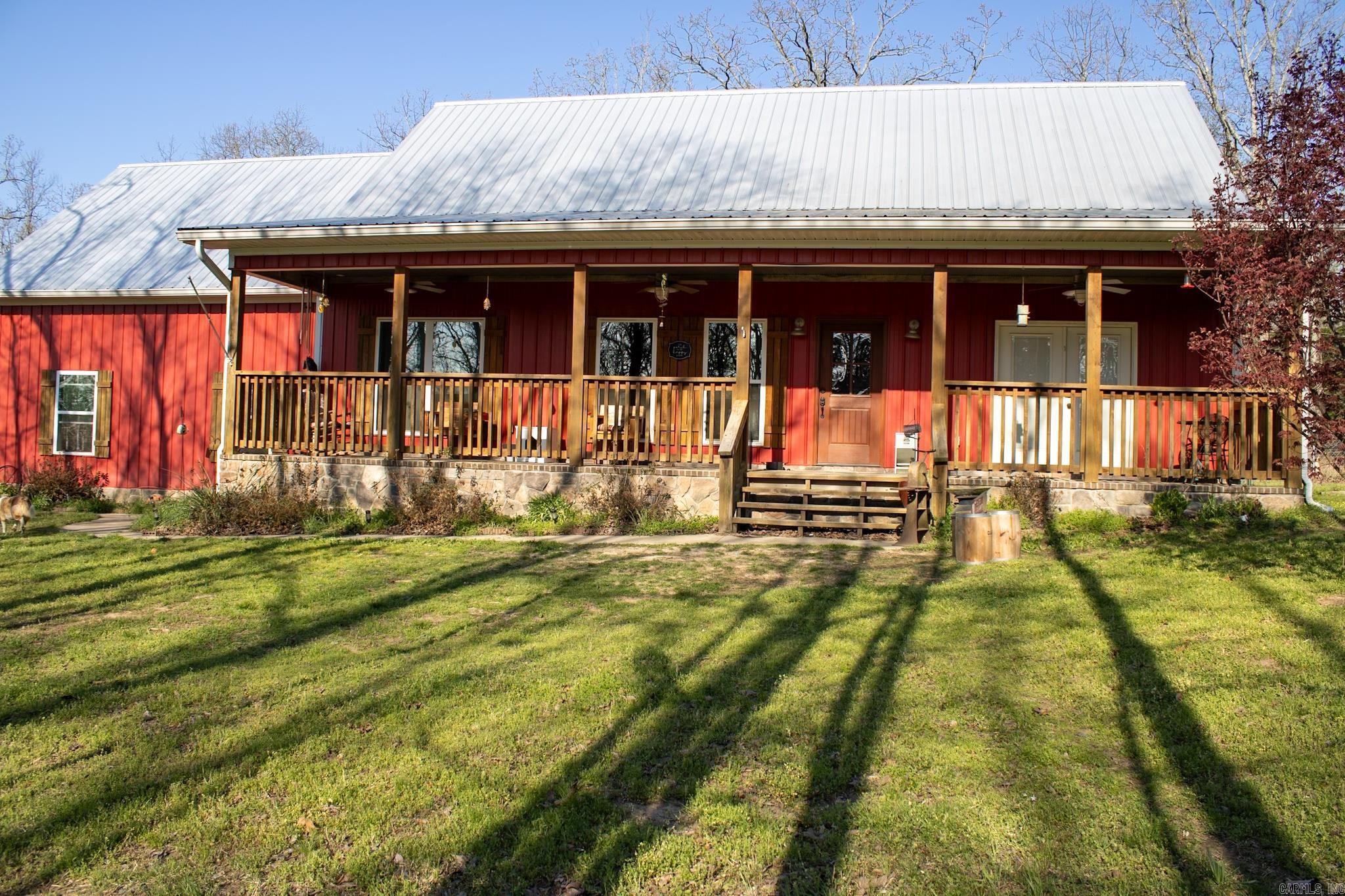 Escape to peaceful country living with this rural residential retreat set on 20 beautiful acres. This 2-bedroom, 2-bath home is tucked into a quiet country tract, offering privacy, space, and endless outdoor enjoyment. Relax on the welcoming front porch and take in the surrounding natural beauty, with plenty of room to explore, hunt, or unwind by the pond—perfect for fishing and quiet reflection. Inside, a cozy sunroom with a fireplace provides a warm, inviting space to enjoy year-round views of the land. The property also features a two-story storage building ideal for equipment, hobbies, or extra storage. A heated and cooled 30x40 shop with a fully functional bathroom adds incredible versatility, whether for work, recreation, or projects. With 52 solar panels helping reduce utility costs, this property combines comfort, functionality, and efficiency. A rare opportunity to enjoy wide-open space and true country living. See Agent Remarks
