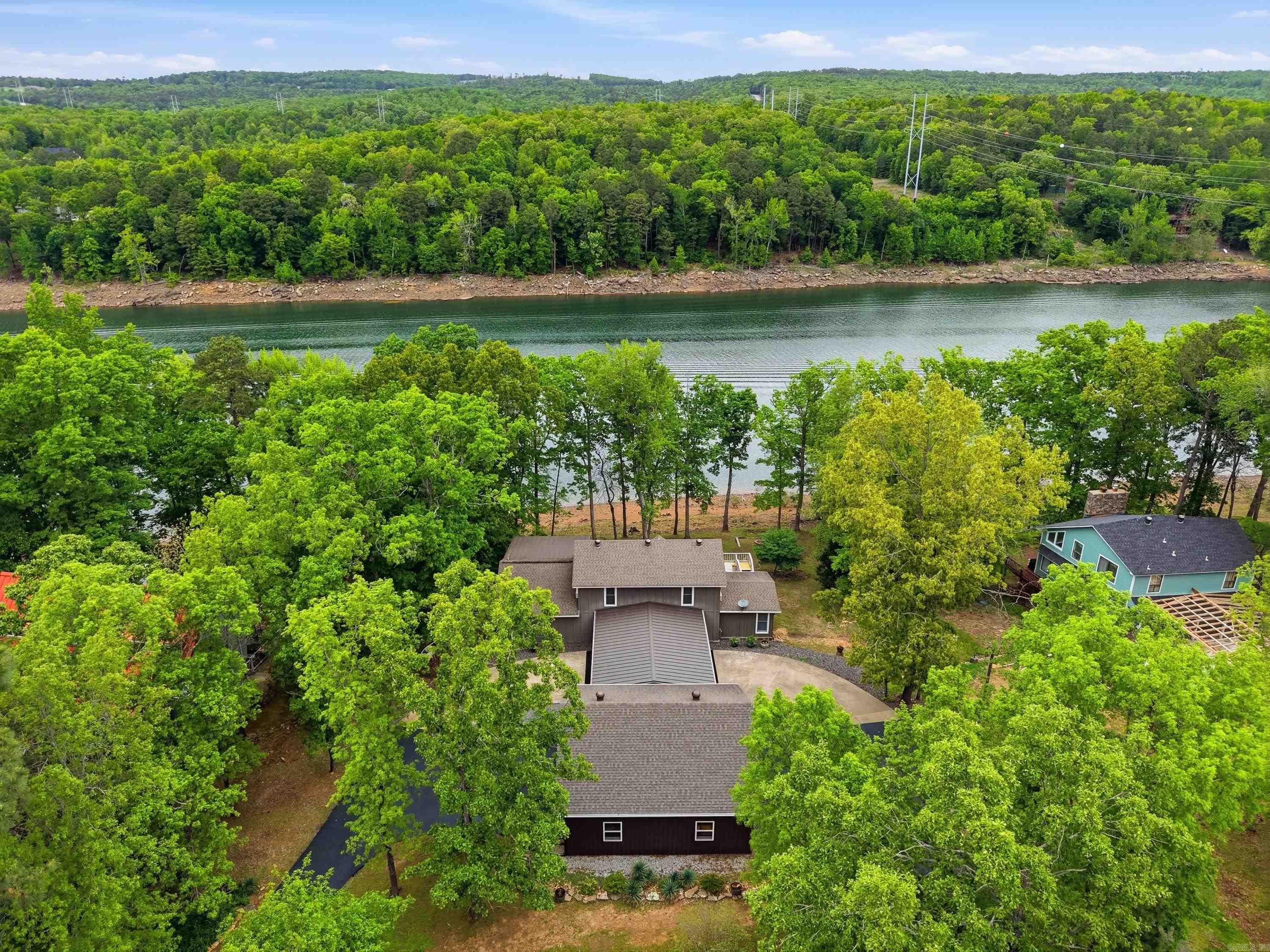 Wake up to sparkling lake views and embrace the ease of true waterfront living in this beautifully updated retreat. A gentle slope leads you to your own pebble beach shoreline—perfect for pulling up your boat, skipping stones, or watching kids play safely at the water’s edge. With several marinas less than 10 minutes away, days on the lake are always within easy reach. Designed with both comfort and entertaining in mind, the screened-in porch offers a serene space for lakeside dining, morning coffee, or evening sunsets, while the expansive deck provides the perfect setting for gatherings with family and friends. Inside, the chef’s kitchen is a true centerpiece, featuring custom cabinetry, upgraded appliances, and convenient pull-out drawers and shelving that make hosting effortless. Extensively upgraded, this home feels like new with updated HVAC, new ductwork, and spray foam insulation for efficiency and comfort. Guest bedrooms each feature their own mini-split systems, ensuring personalized climate control. A heated and cooled workshop adds incredible versatility for hobbies, storage, or projects. This is more than a home—it’s a lifestyle.  See all upgrades in document files.