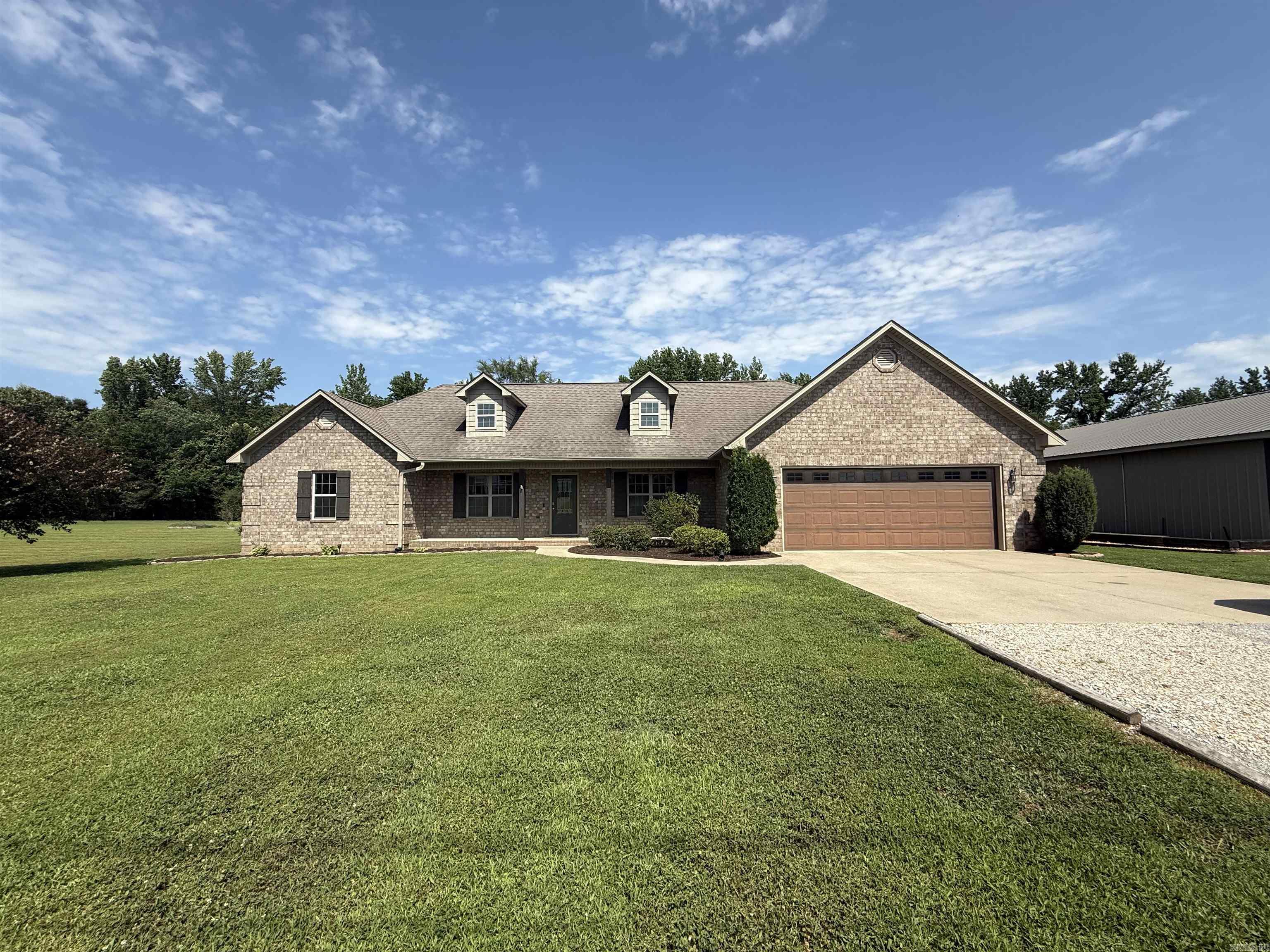 Experience the best of both worlds with this exceptional 4-bedroom, 2-bath home nestled on 1.51 scenic acres, offering peaceful country living just minutes from city conveniences. Designed with comfort and functionality in mind, the spacious split floor plan provides privacy for the primary suite while creating inviting spaces for family and guests. Open living areas filled with natural light and a generous bonus room featuring a cozy fireplace—perfect for relaxing evenings, entertaining, or creating a flexible space to fit your lifestyle. The primary suite is a true retreat with an oversized walk-in closet, while the large laundry room and thoughtfully designed layout make everyday living effortless. Outside, is equipped with an impressive workshop with a kitchen and bathroom area, and an additional room that could easily be converted into a guest suite, home office, or apartment. A convenient lean-to provides covered parking for a boat, ATV, golf cart, or outdoor equipment, and an RV electrical hookup is already in place. Unwind on the large partially covered deck, ideal for entertaining guests or taking in the peaceful surroundings. Fresh paint & heat/air unit less than year old