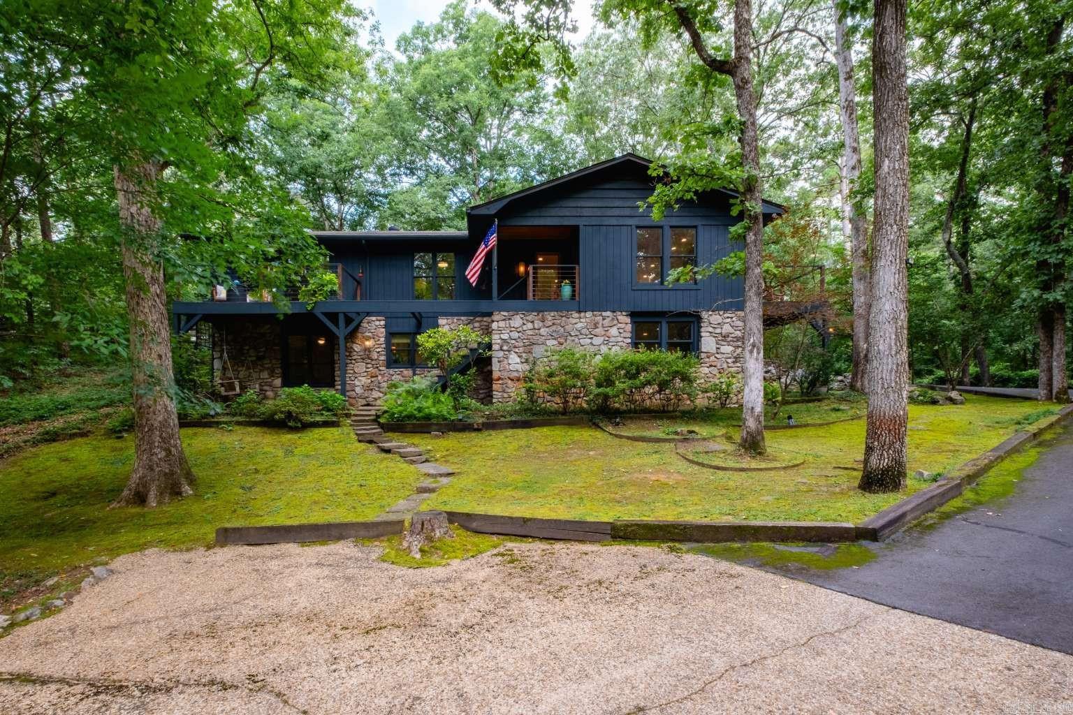 NEW PHOTOS AND VIDEO TOUR ADDED Stunning as fully remodeled 1974 mid-century home on 7 private acres offering 3,560 sq ft, 4 bedrooms, 3 full baths, and two spacious levels.Beautifully updated property blends timeless character with modern comfort through extensive interior and exterior renovations.Surrounded by mature trees and landscaped grounds, the property offers exceptional privacy while being just 5 minutes from The Promenade, restaurants, shopping, and conveniences. Features include a whole-home generator, sprinkler irrigation system, wraparound deck, 400 sq ft pavilion, two ventless log fireplaces, downstairs storage/safe room, and an 800 sq ft detached two-car garage connected by a breezeway.A rare highlight is the heated and cooled 3,200 sq ft shop with its own private driveway, ideal for a business, workshop, storage, or hobby space. A handmade front gate adds charm and curb appeal. Several interior and exterior items convey with purchase. Rare opportunity to own a private, move-in-ready estate with acreage and unmatched versatility.Located near Chenal Elementary and outside city limits, this unique property combines convenience with seclusion. A must-see property
