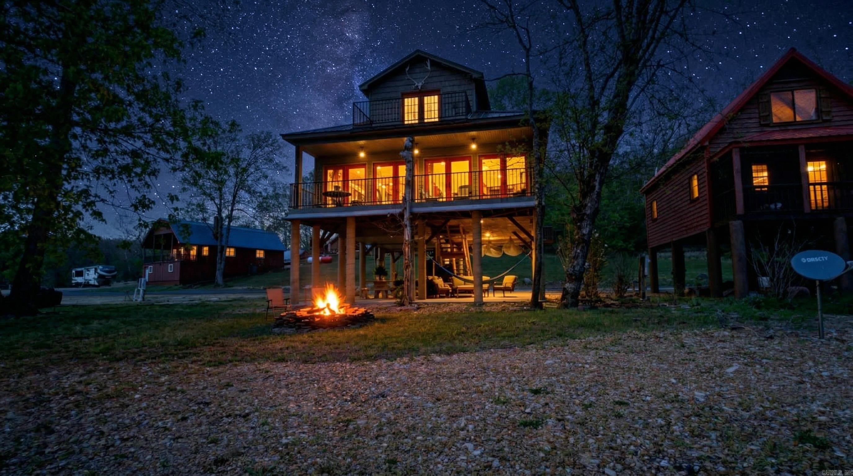 Spring River Riverfront Retreat with Private Access & Luxury Living  Enjoy direct access to the water from your own lot, complete with a private gravel shoreline perfect for fishing, swimming, or relaxing. The home features a full-width covered deck overlooking the river and a shaded patio below for additional outdoor space and storage for kayaks and river gear. Elevated on concrete piers, it is designed for protection during high water.  This 1,524 sq ft, two-story home sits on a 0.31-acre lot and offers 3 bedrooms and 2.5 bathrooms. The main level includes a master suite with a soaker tub and tiled shower, along with the kitchen, dining, living area, and half bath with laundry. Upstairs features two bedrooms and a full bath. The kitchen includes granite countertops, custom cabinetry, and stainless steel appliances. Additional features include central heat and air, a tankless water heater, gated entry, and a fire pit.