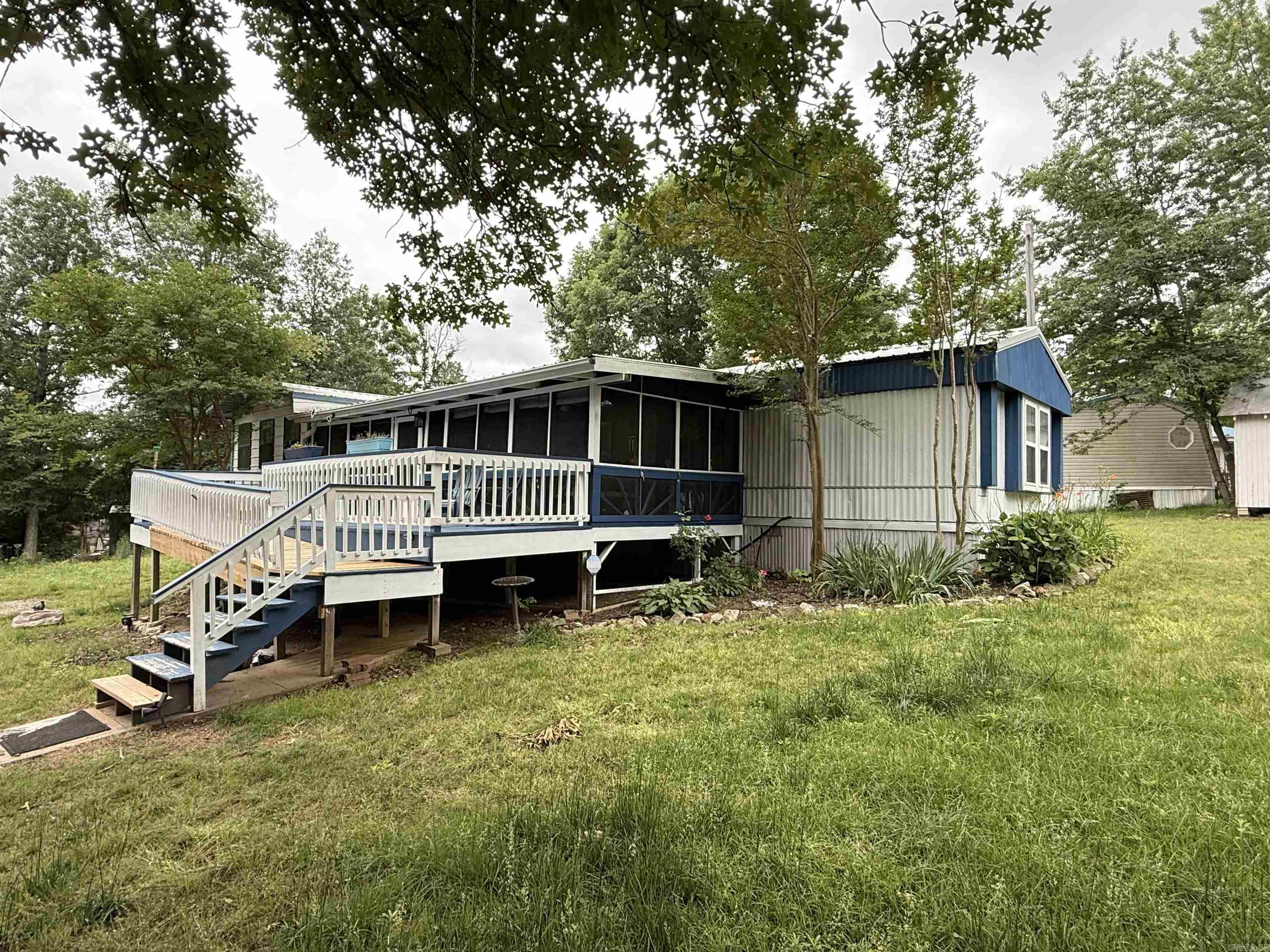 Just minutes from Norfork Lake, this well-maintained mobile home offers 2 bedrooms, 2 baths, and a versatile bonus room. Enjoy relaxing outdoor spaces with a large front, screened-in porch, front deck, and covered back deck. The large garage includes a built-in tornado shelter for added peace of mind. Recent updates include newer heating and air systems, making this property both comfortable and practical.