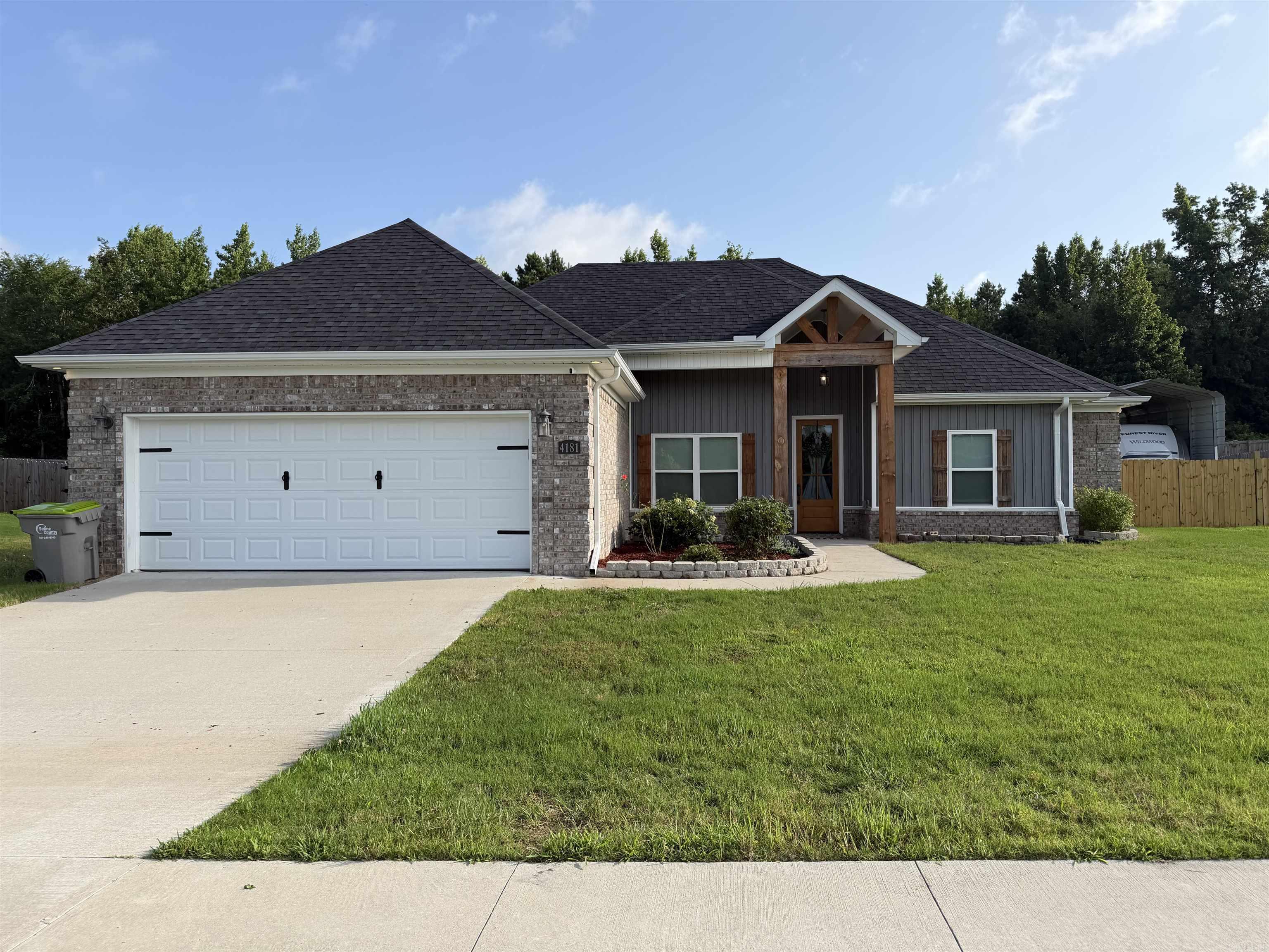 Built in 2023, this 2,057-square-foot home in Crossroads Village offers the perfect blend of style and functionality. Featuring 3 bedrooms, 2 bathrooms, and an open-concept layout, the spacious living room showcases a stunning 12-foot vaulted ceiling, while 9-foot ceilings throughout the rest of the home create a bright, airy feel. Quartz and granite countertops, black stainless-steel appliances, and a gas fireplace add modern style throughout the home. The thoughtfully designed floor plan includes a dedicated office or flex space with a sliding barn door, a convenient mudroom, and walk-in closets that provide generous storage. Step outside to enjoy the large, fenced backyard, offering plenty of space to relax, entertain or enjoy outdoor living, along with a covered RV parking pad for your recreational vehicle, boat, or additional parking. Situated on a .42-acre lot, the backyard backs to a wooded area, offering added privacy and peaceful natural setting. Located just off Highway 70 in Crossroads Village, this home offers a peaceful setting just minutes from Benton and is in the Harmony Grove School District.