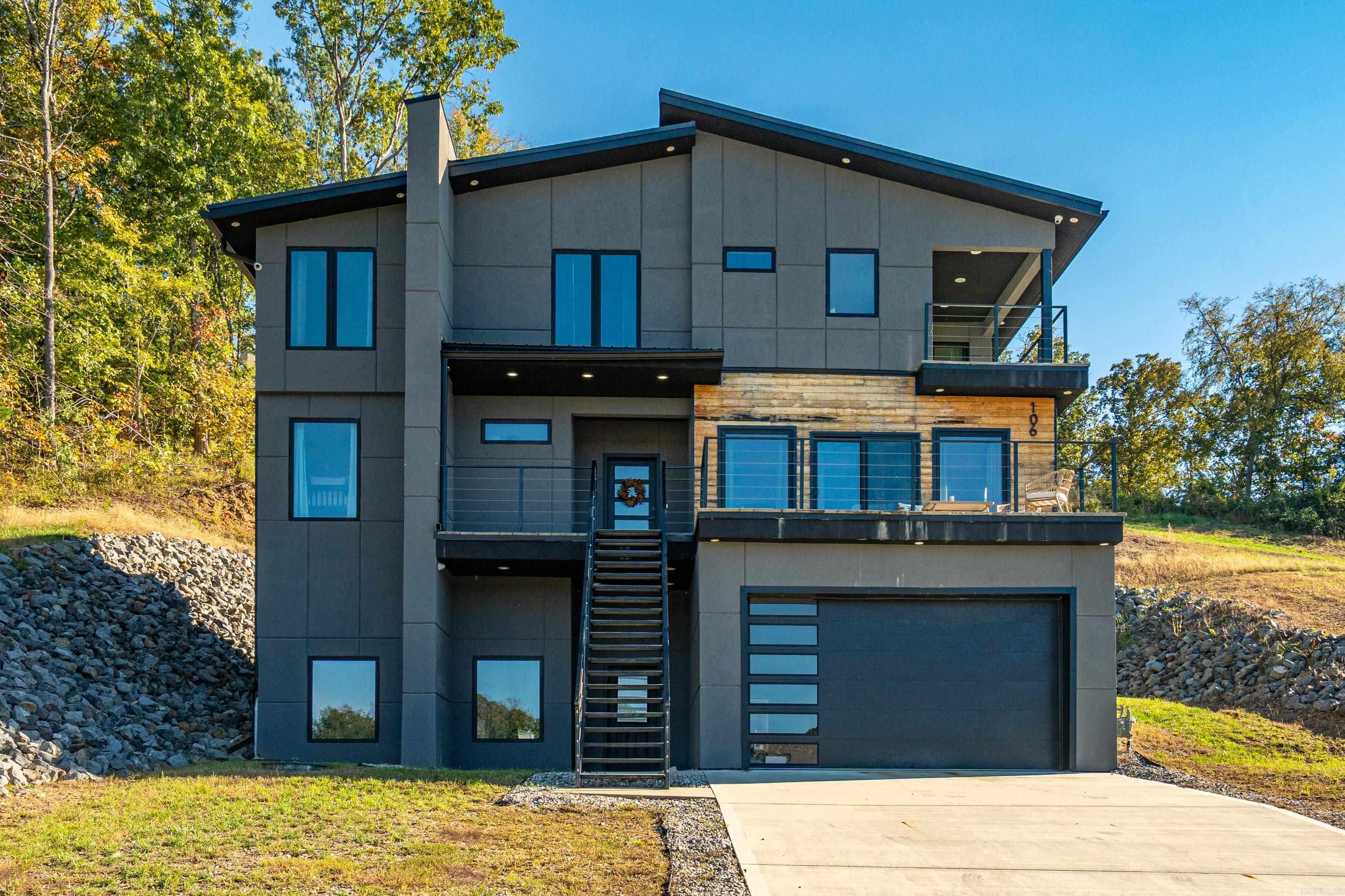 Modern luxury and beautiful lake views! Featuring 5 spacious bedrooms, a bonus room, and 3.5 bathrooms, this thoughtfully designed home blends comfort, style, and efficiency. Situated directly across from Lake Hamilton, this property is perfect as a full-time residence or relaxing retreat. Built with quality and performance in mind, this high-efficiency home includes top-of-the-line materials and systems throughout. Upgrades and features include a 40-year metal roof with synthetic felt ice and water shield, 6” spray foam insulation, and added sound insulation between floors. Enjoy improved air quality with a fresh air intake system, while all exhaust is vented outside. The home is equipped with two dual-zoned HVAC units, a high-grade tankless water heater, and a hot water recirculation pump for convenience. The kitchen boasts a slide-in range with gas cooktop and electric convection oven, complemented by under-cabinetlighting and modern finishes throughout, including floating cabinets and smart closet lighting. Additional highlights include Low-E double-pane Quaker windows, French drains, Wi-Fi thermostate and garage door opener, and a pre-installed electric vehicle charging.